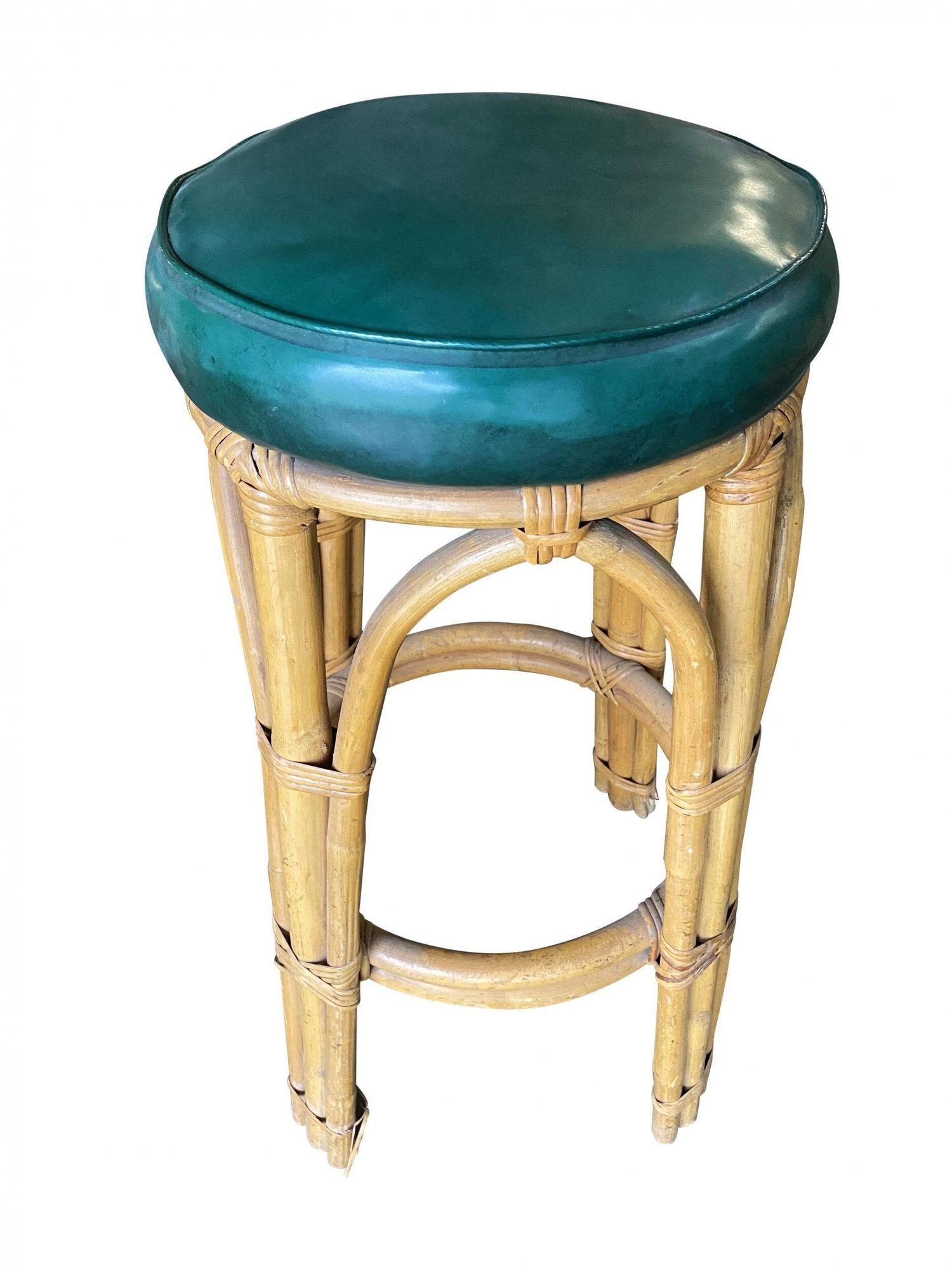 Restored three-stand arched base rattan bar stool with dark green vinyl seat. The stool features a foot great along the bottom
1950, United States
We only purchase and sell only the best and finest rattan furniture made by the best and most