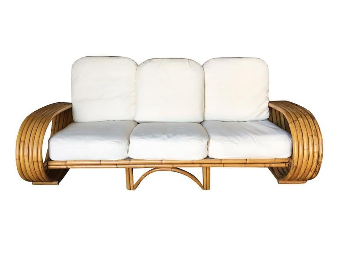 Dieses wunderschön restaurierte, von Paul Frankl inspirierte Rattan-Dreisitzer-Sofa mit sechs Strängen und einem einzigartigen, gewölbten Mittelboden aus Stangenrattan. Dies ist ein großartiges Beispiel für ein amerikanisches Nachkriegs-Sofa im Stil