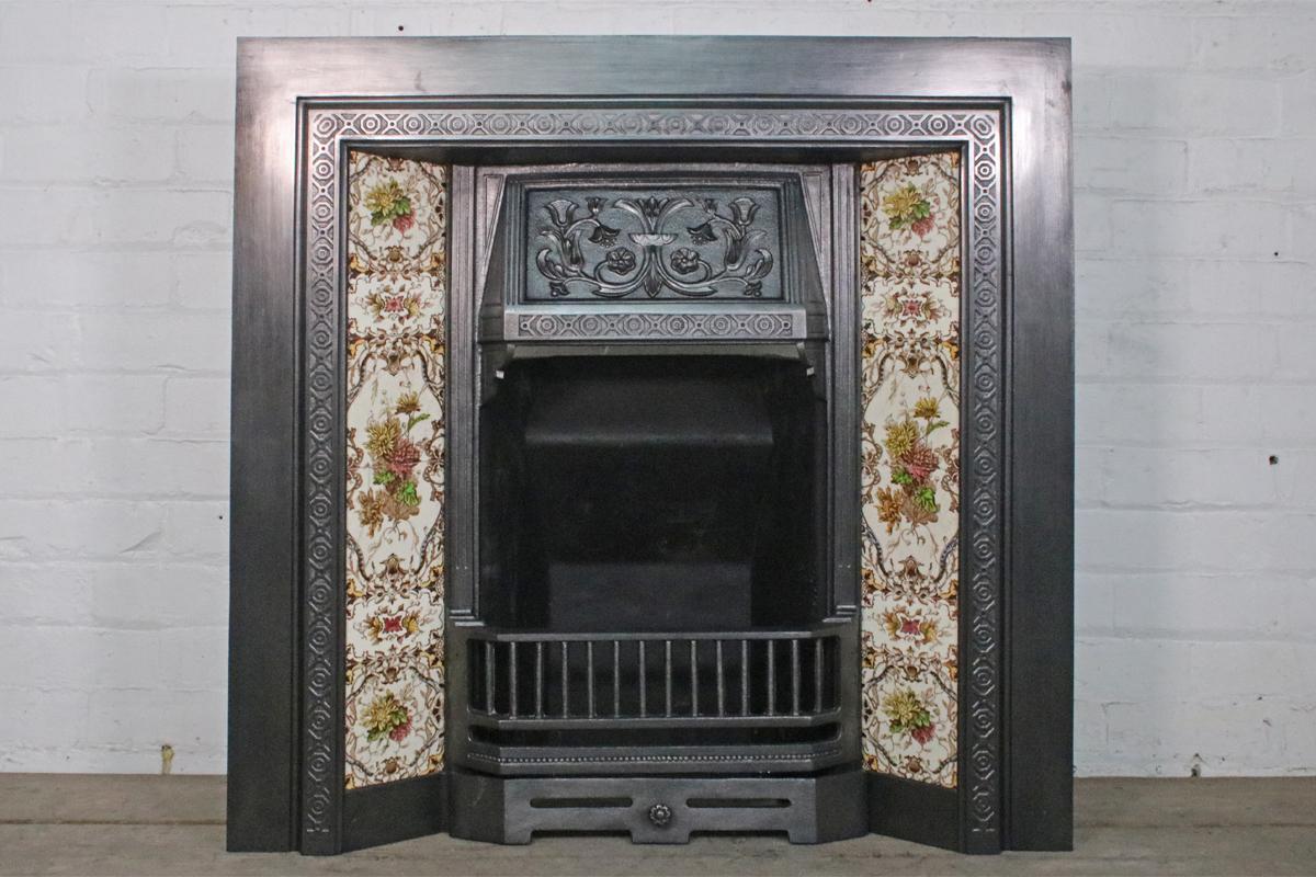 A good example of an antique Edwardian cast iron grate. 
Complete with a set of original fireplace tiles.

This grate has been finished the traditional black grate polish, leaving a gun metal / pewter shine.
Ready to be installed and used for a