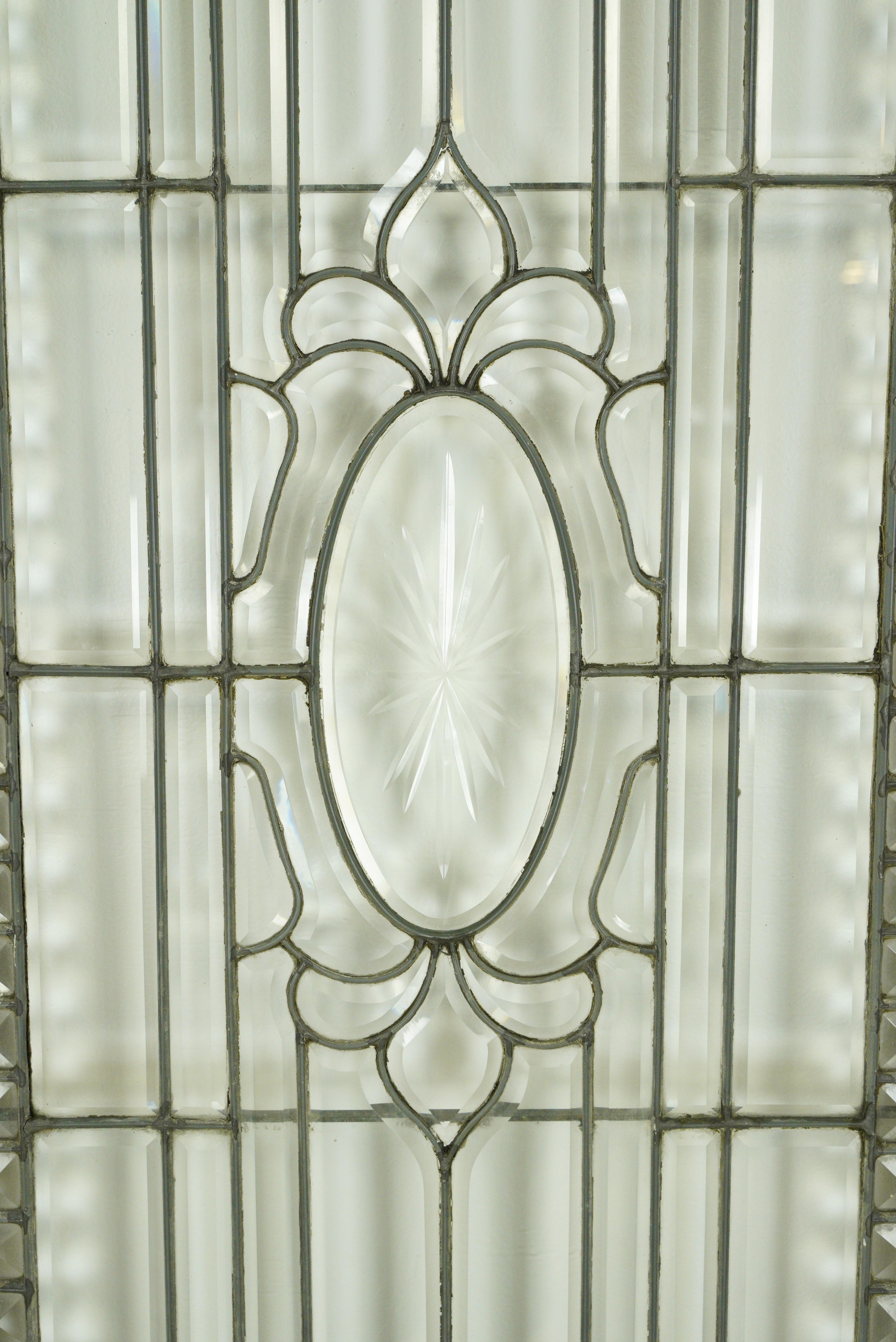 Puerta de entrada antigua de cristal emplomado restaurada en muy buen estado. La madera se ha repintado y la cavidad de la cerradura de embutir se ha rellenado y ajustado para conseguir un picaporte moderno que combine con los pomos antiguos de las