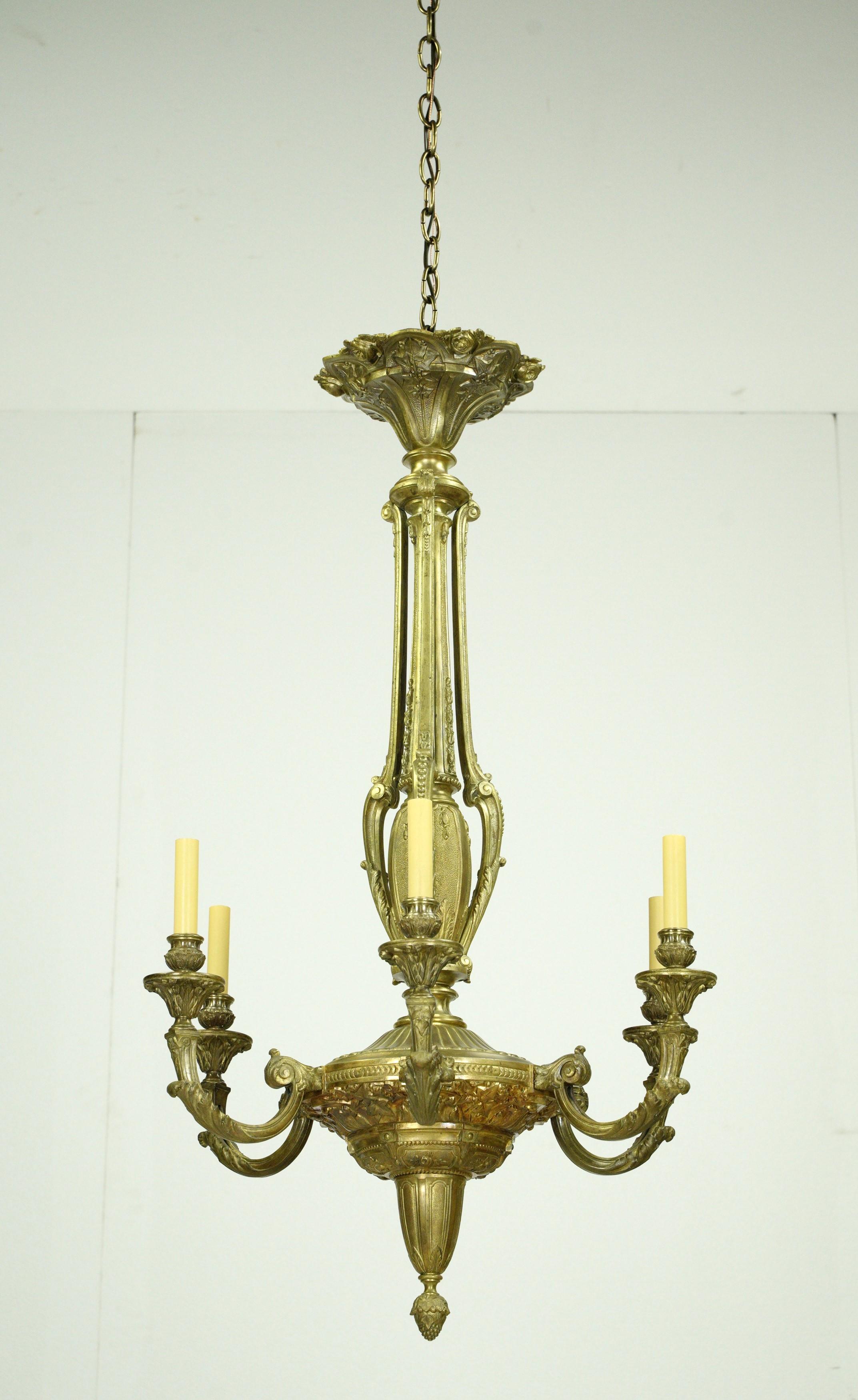 Carefully restored to its former glory, this chandelier showcases the beauty of French design. Featuring six ornate arms and crafted from bronze, this light is wired and ready to ship. This light requires six candelabra light bulbs. Cleaned and