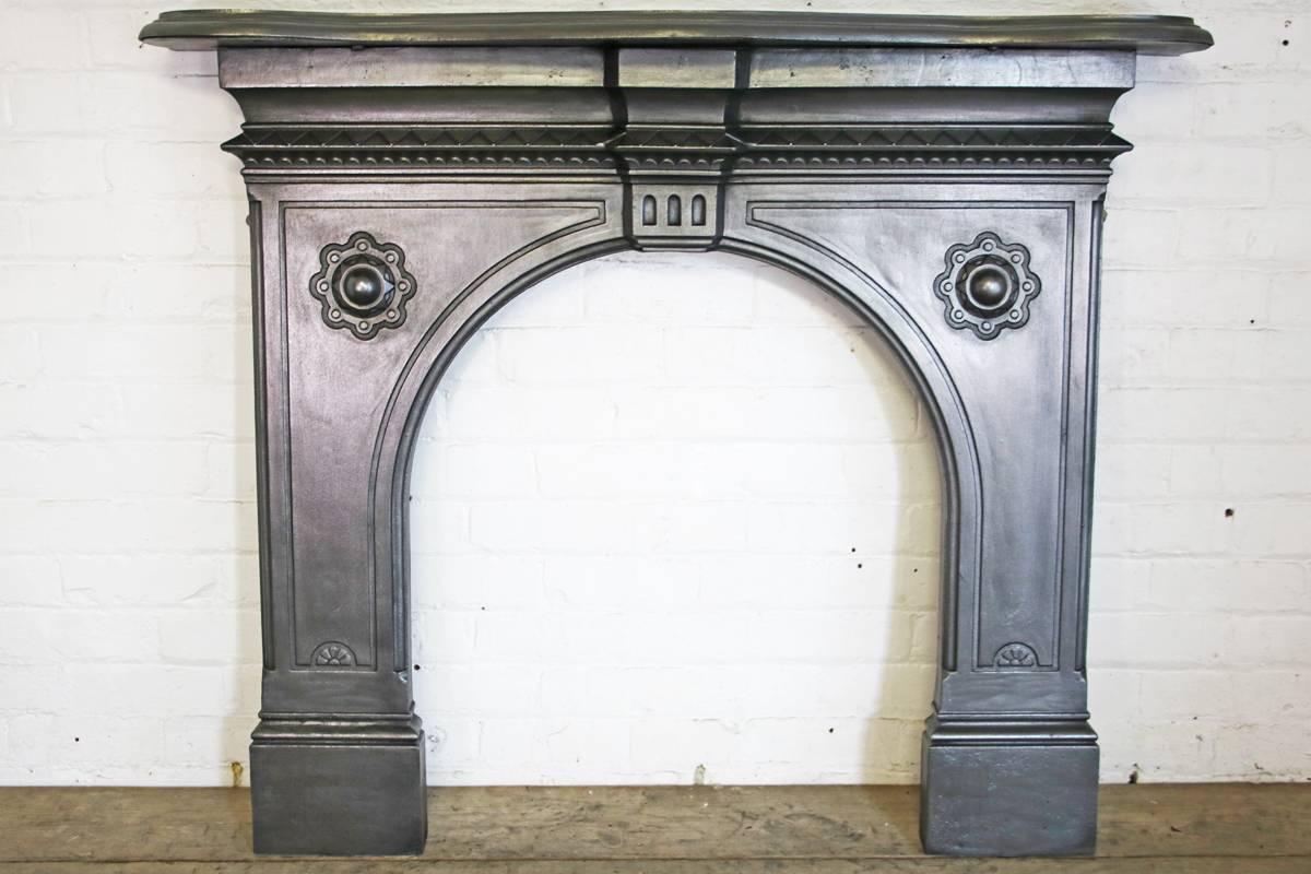 19th century Victorian cast iron fireplace surround with arched aperture and serpentine shaped shelf, circa 1877. Removed from a bedroom of a terrace house in Altrincham, Cheshire. England. 

This surround has been finished with traditional black