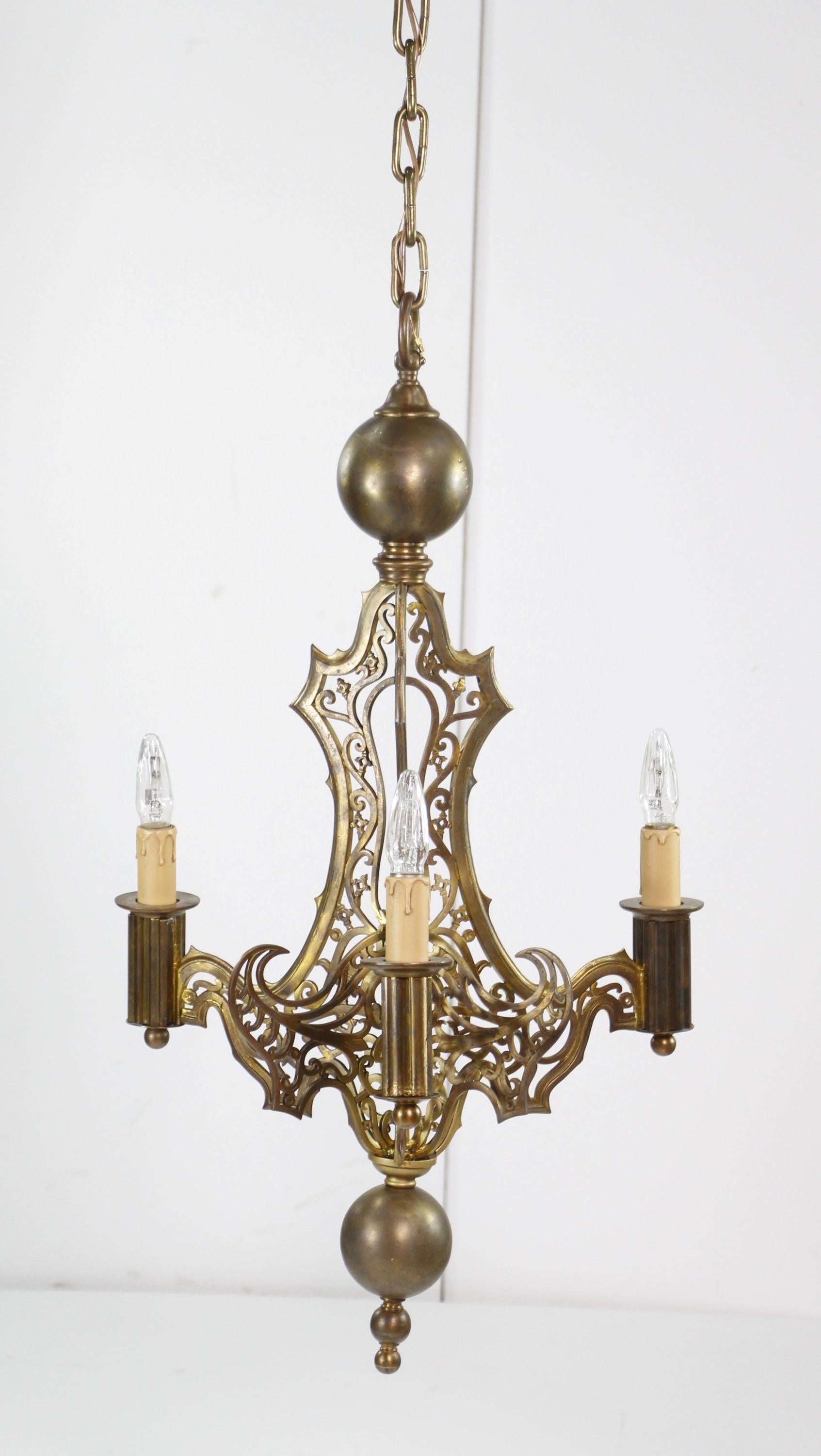 20th Century cleaned and restored three arm cast bronze chandelier. Done in a Gothic styling. Cleaned and restored. Brass finial details. Chain and canopy are brass also. Small quantity available at time of posting. Please inquire. Priced each.