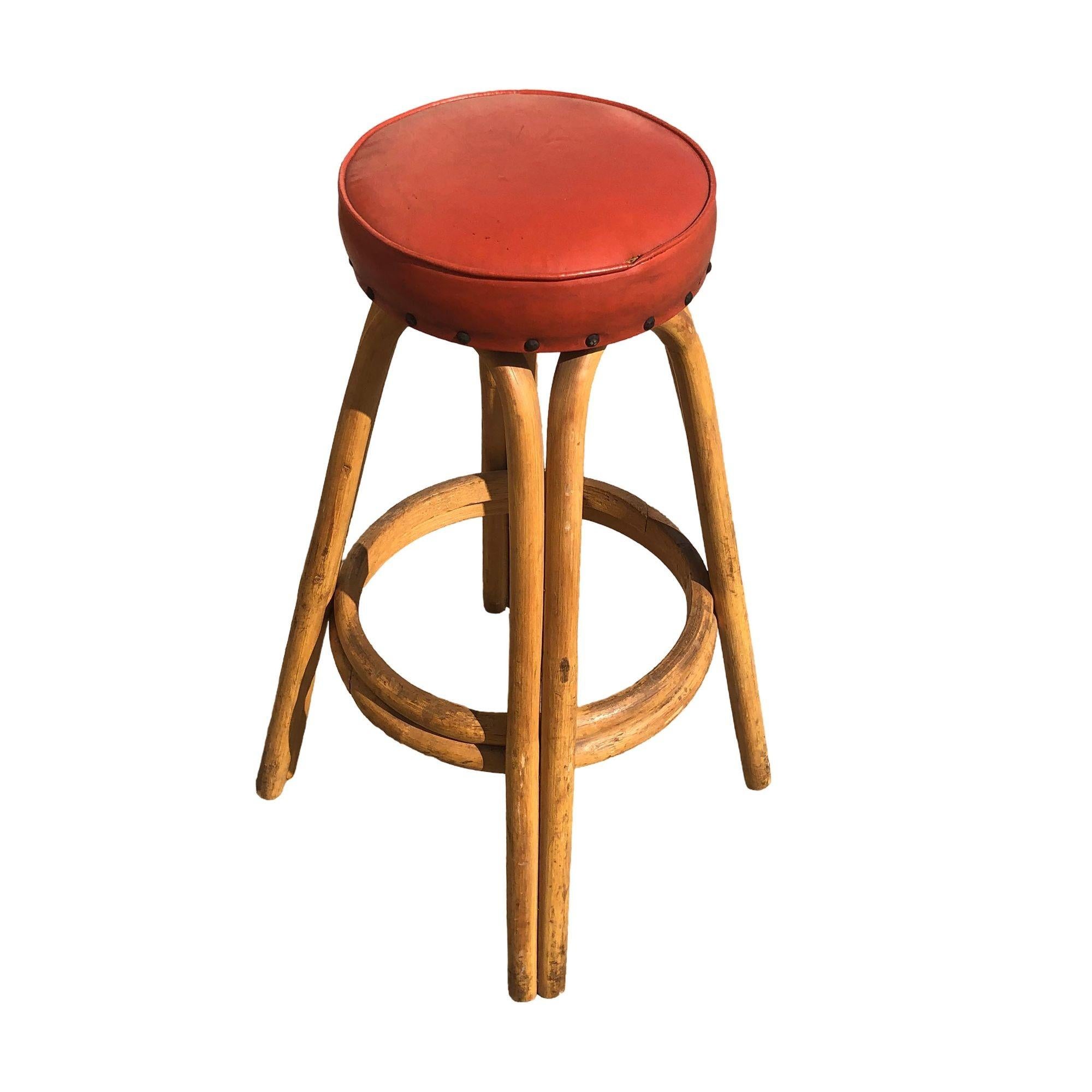 Elevate your space with this set of five restored Mid-century arched rattan bar stools, each adorned with striking studded red cushions. Crafted with arches on each side of the stool and two-stranded legs, this piece combines Mid-century era styling