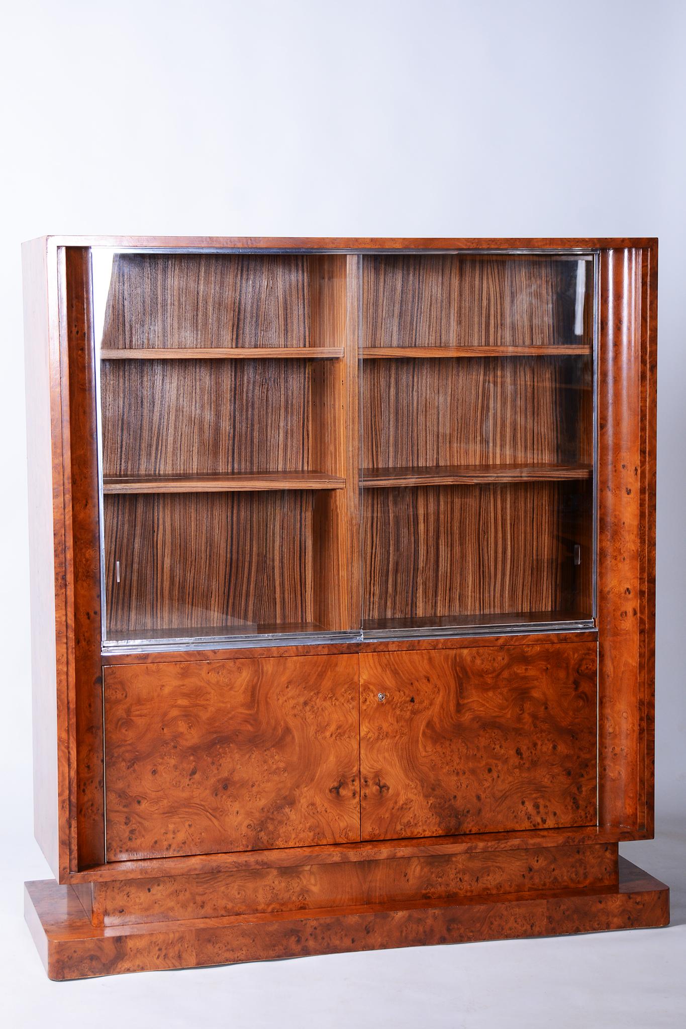Cette exceptionnelle bibliothèque Art déco provient de France, dans la première moitié du XXe siècle, et témoigne d'un savoir-faire artisanal de premier ordre et de matériaux luxueux. Sa carcasse est fabriquée à partir de panneaux de bois plaqués de