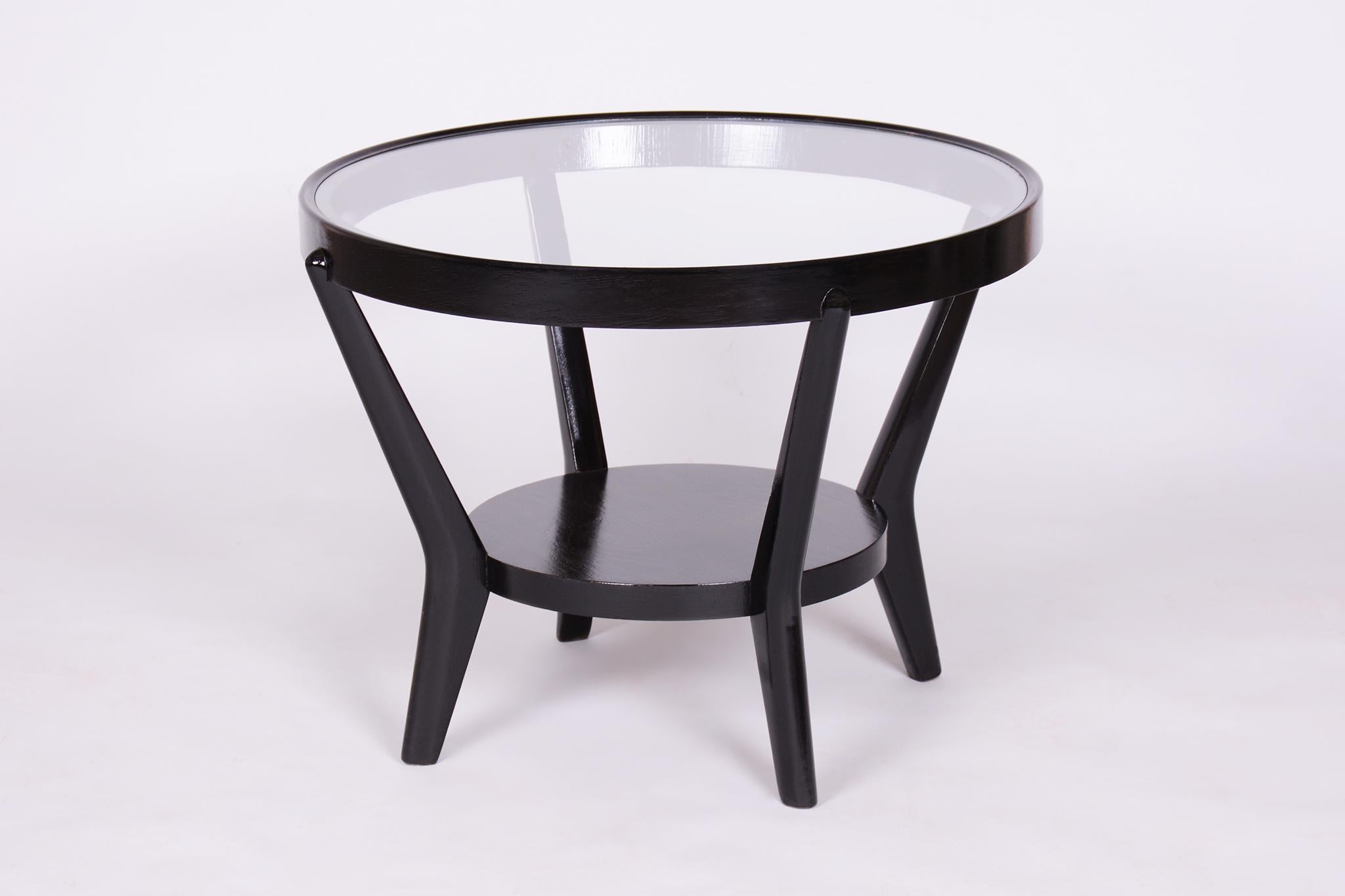Cette table basse ronde iconique de style Art Deco, conçue par les designers Karel Koželka et Antonín Kropáček, provient de Tchécoslovaquie des années 1940. Il a été fabriqué par České umělecké dílny et impressionne par son design intemporel et sa