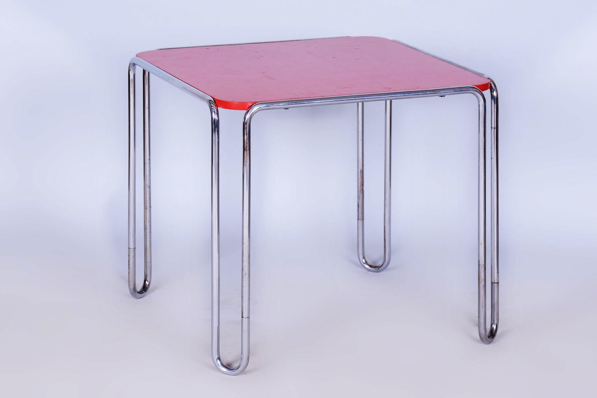 Dieser elegante, im Bauhaus-Stil entworfene Tisch stammt aus dem Deutschland des frühen 20. Jahrhunderts. Das von Thonet hergestellte Möbelstück besticht durch seine Kombination aus verchromtem Stahlrohr und einer rot lackierten Tischplatte aus