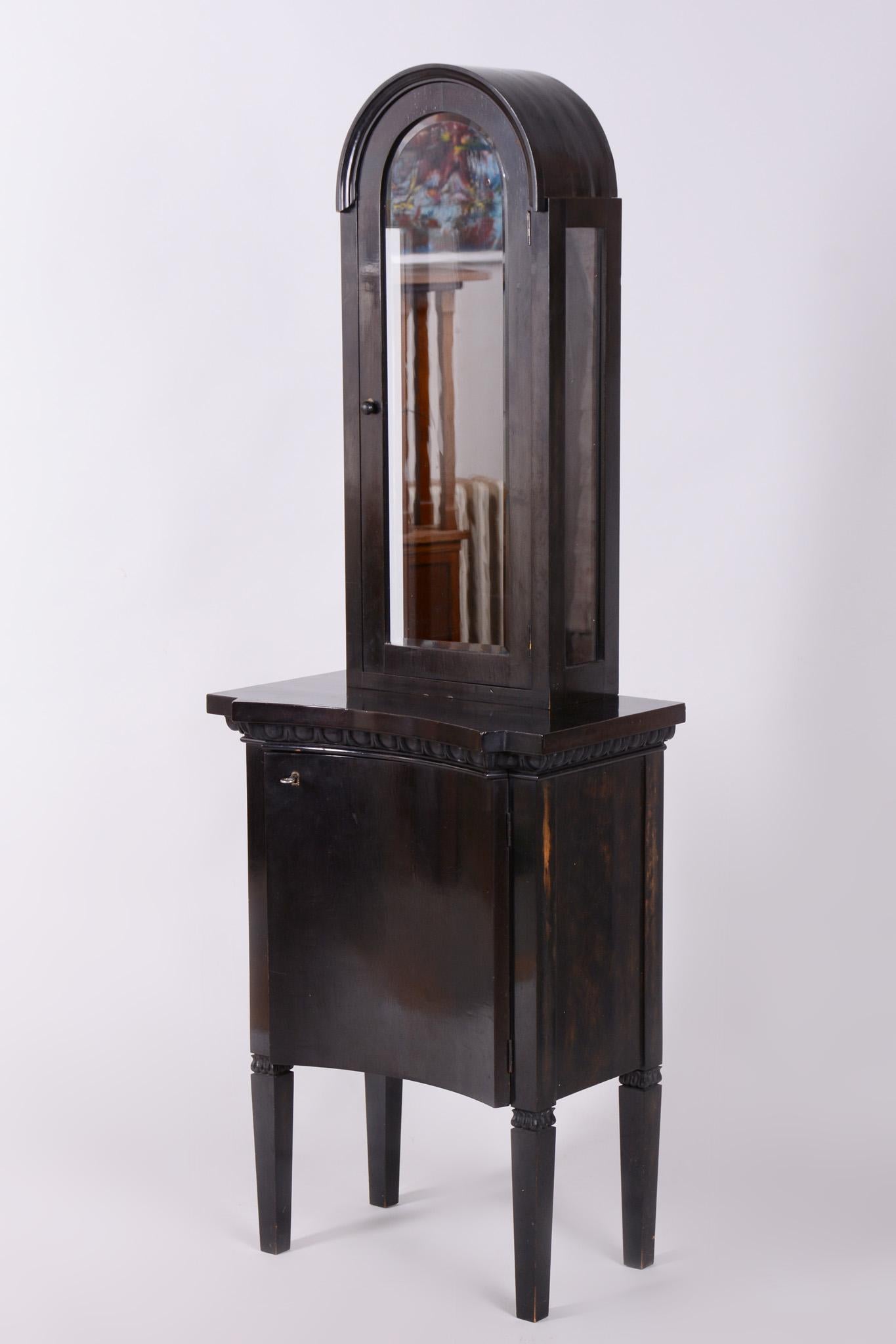 Este elegante mueble vitrina Art Decó procede de Francia, de principios del siglo XX. Está fabricado con tablero de bloque chapado y ennegrecido, lo que le da un aspecto sofisticado y moderno, típico de esta época.

El artículo consta de dos partes