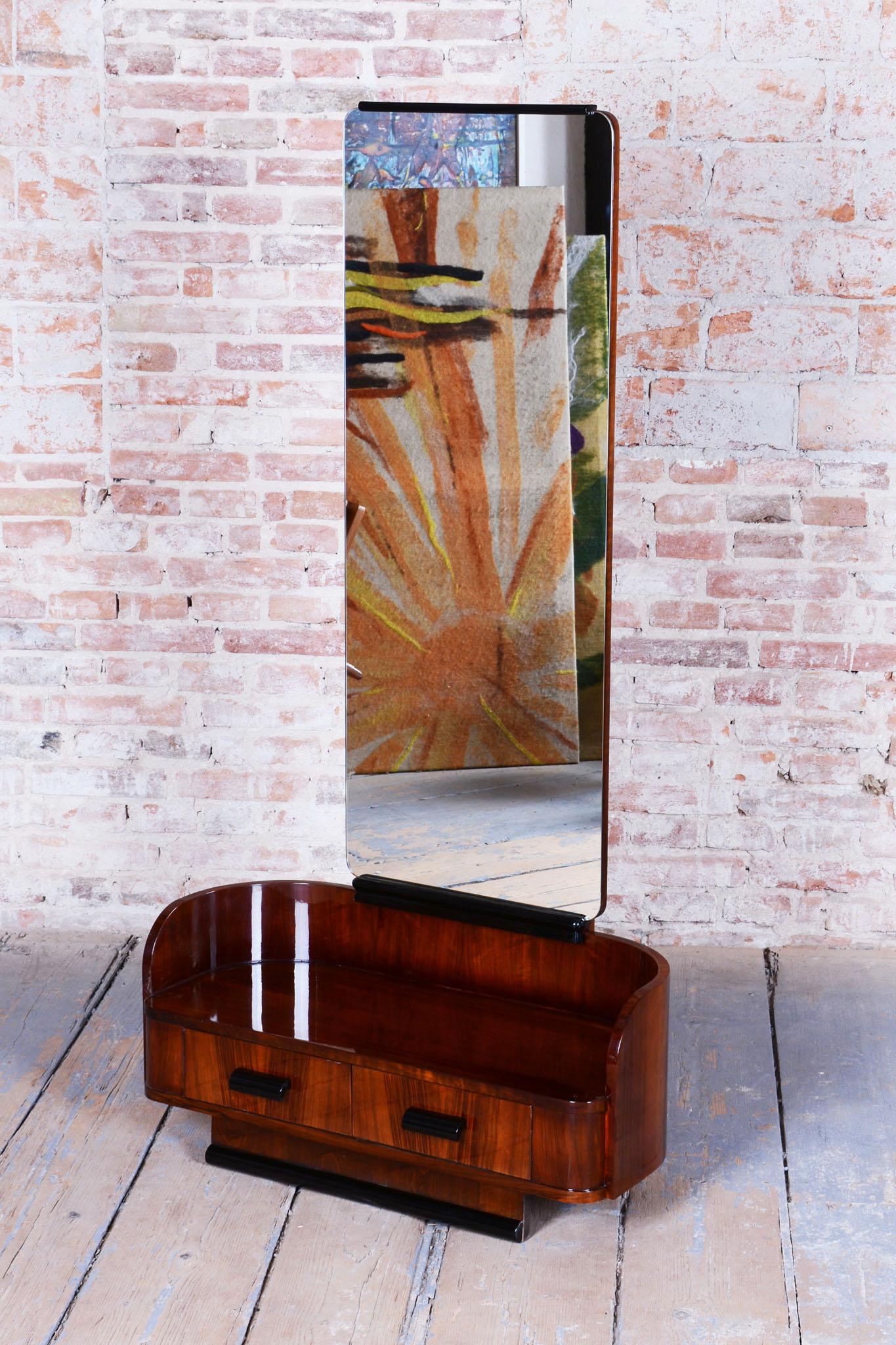 This elegant Art Deco dressing table with mirror comes from Czechoslovakia from the first half of the 20th century. It is the work of Jindřich Halabala and was produced in UP Zavody. The dressing table is made of blockboard veneered with walnut and