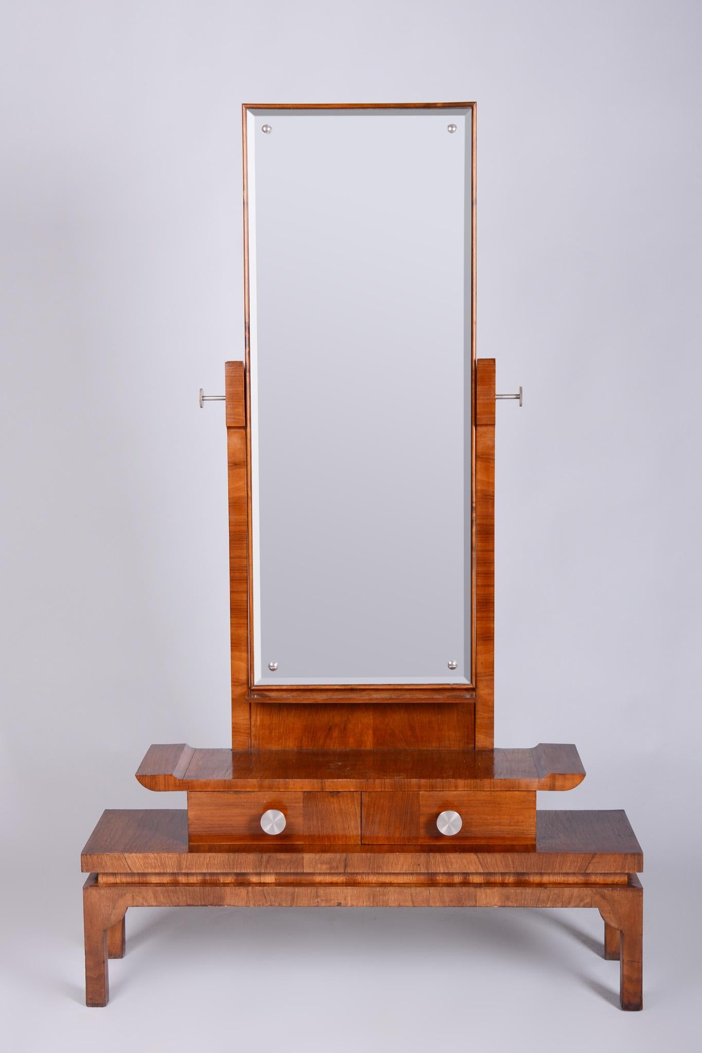Questa elegante toeletta Art Deco con specchio proviene dalla Cecoslovacchia e risale alla prima metà del XX secolo. È realizzato in impiallacciatura di noce e ha maniglie nichelate.

La toeletta è stata sottoposta a un accurato restauro, durante il