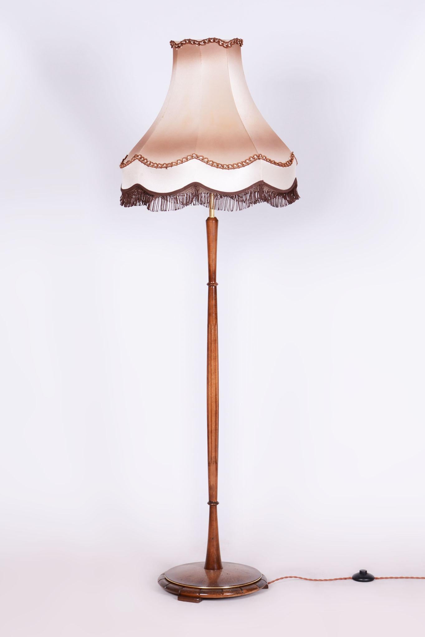 This elegant Art Deco floor lamp comes from Czechoslovakia from the first half of the 20th century. It is made of beech wood and has a textile lampshade.

The lamp has undergone careful restoration, during which its original shine and elegance were