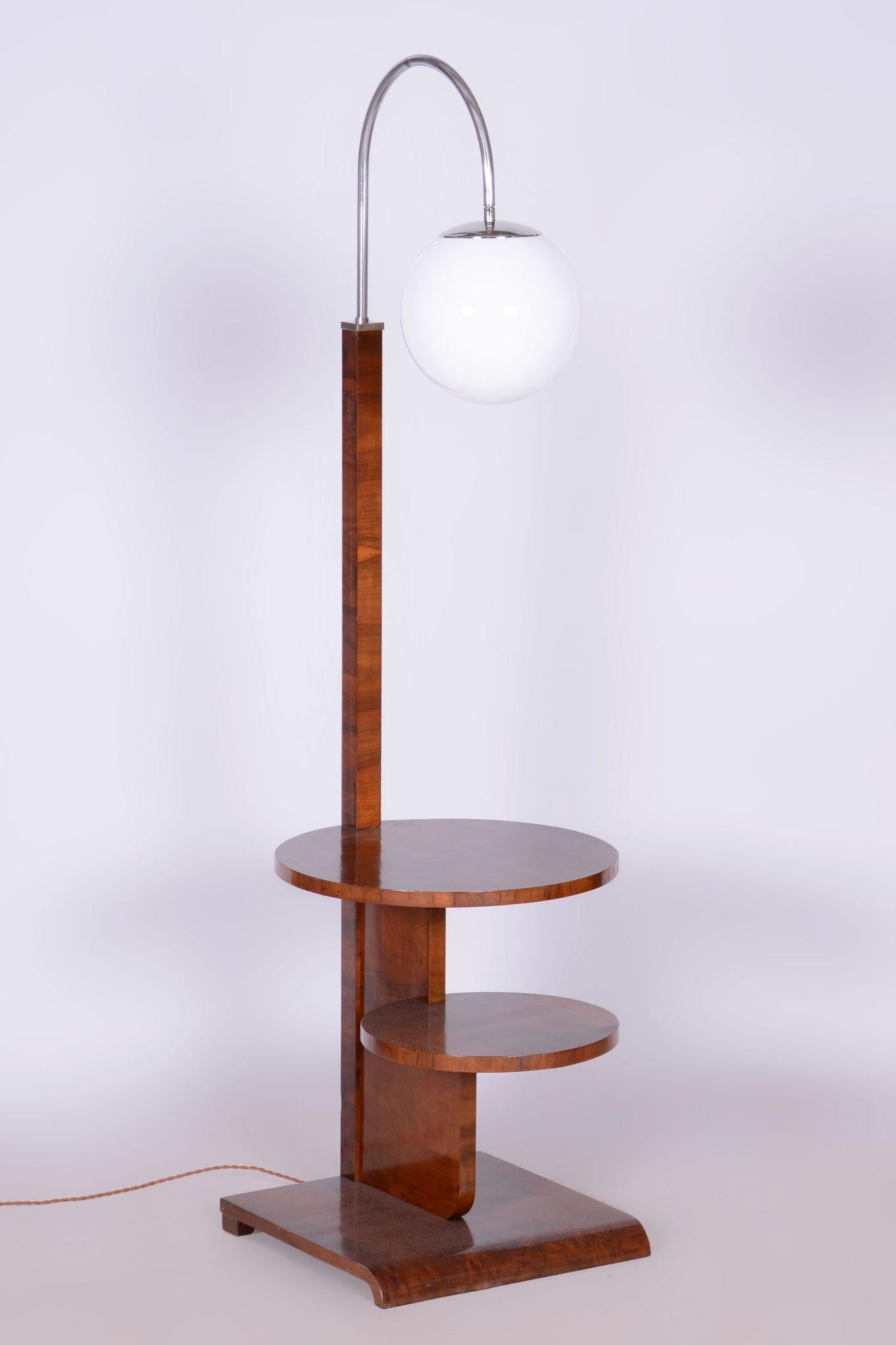 Ce superbe lampadaire Art déco est l'œuvre du célèbre designer Jindřich Halabala et a été produit par Up Závody. Il est fabriqué en bois de hêtre avec un élégant placage en noyer.

La lampe est dotée d'un abat-jour en verre opale blanc en forme de