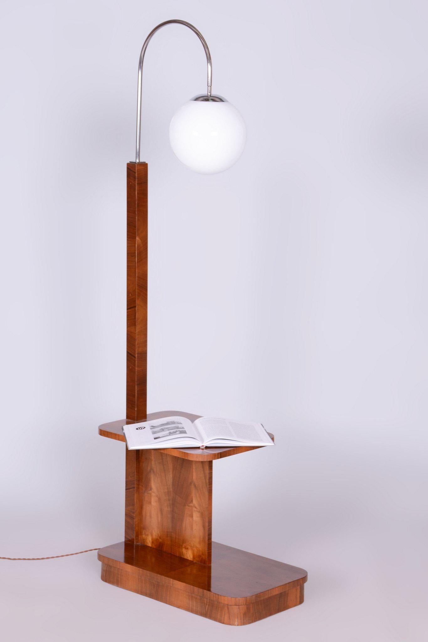 Questa lampada da terra Art Déco risale agli anni '30 ed è stata realizzata in Cecoslovacchia. È stato progettato dal famoso architetto Jindřich Halabala e prodotto da UP Závody Brno.

La lampada è impiallacciata in noce. Il tubo in acciaio cromato