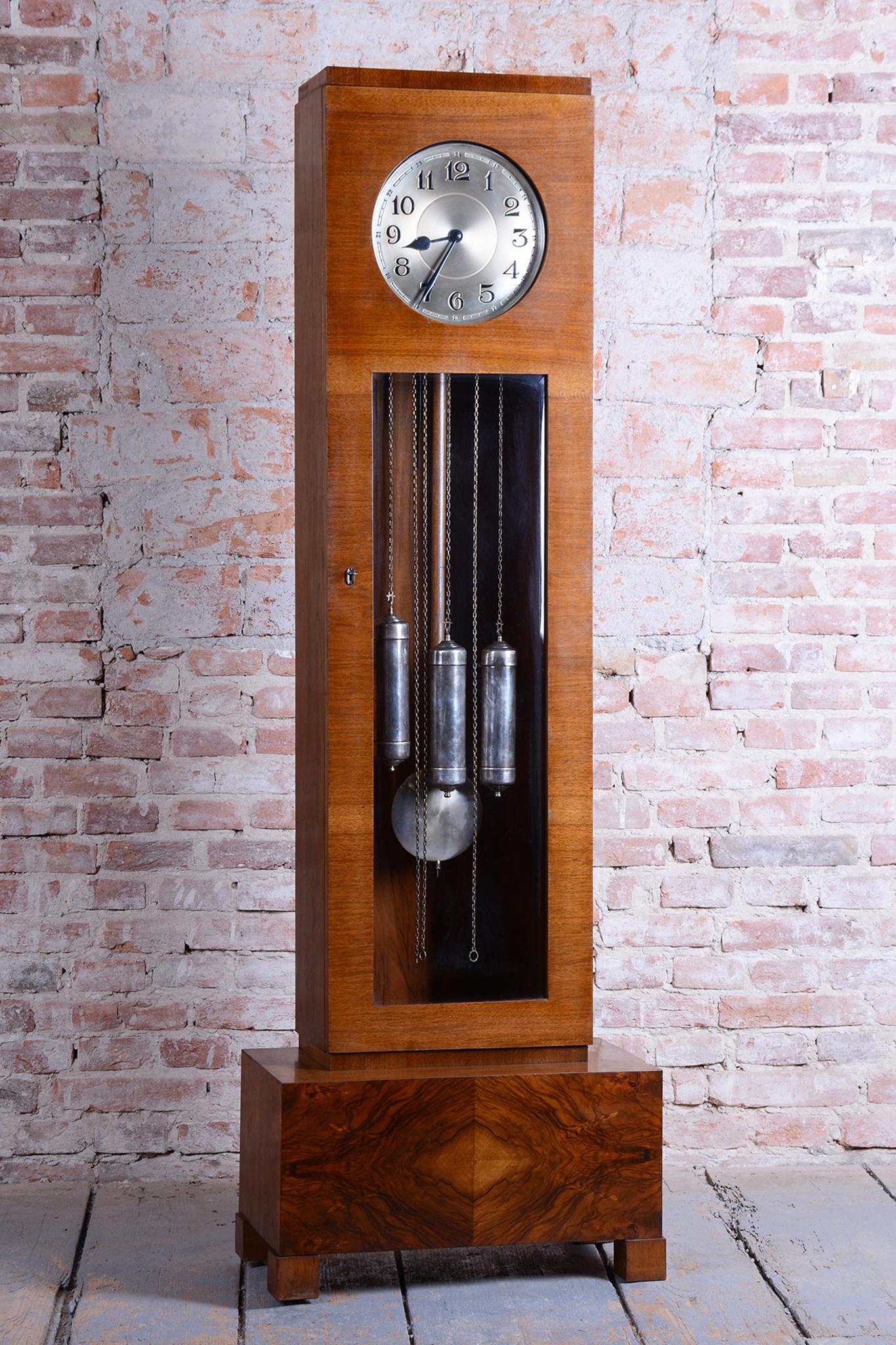 This majestic Art Deco grandfather clock represents the pinnacle of Czechoslovak furniture design from the 1920s. Its elegant, geometric lines combined with wood and metal are a perfect example of the era design.

The clock case is crafted from