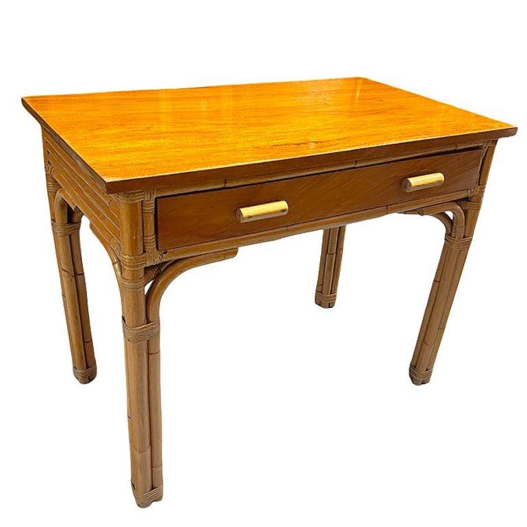 This beautifully restored rattan and mahogany writing desk embraces the fusion of timeless beauty and functionality. Featuring a convenient drawer adorned with rattan drawer pulls and supported by four-strand legs, this desk seamlessly marries