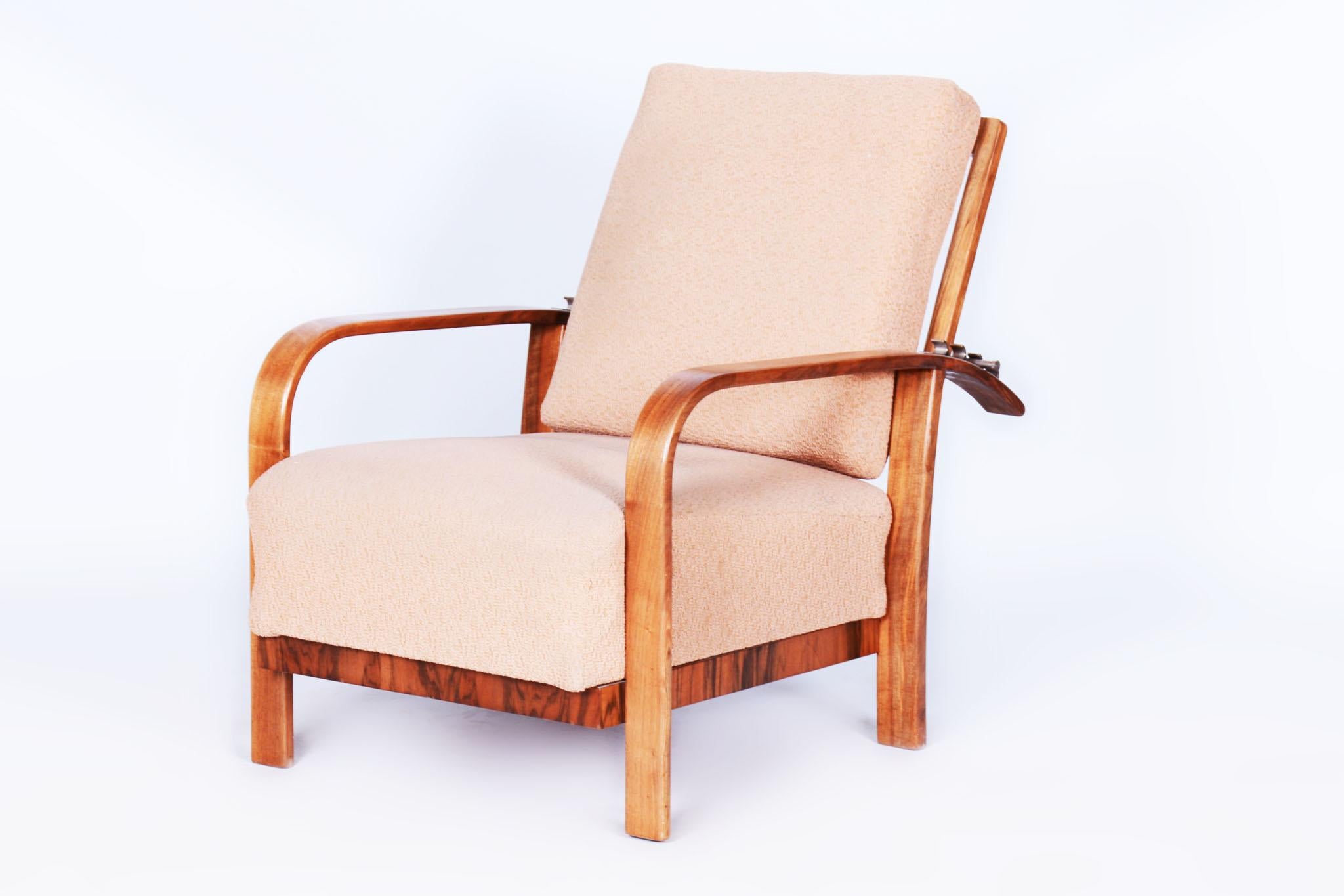 Cet élégant fauteuil inclinable Art déco provient de Tchécoslovaquie et date du début du 20e siècle. Il est fabriqué en noyer massif et plaqué et impressionne par son design intemporel et sa précision artisanale.

Le fauteuil a fait l'objet d'une