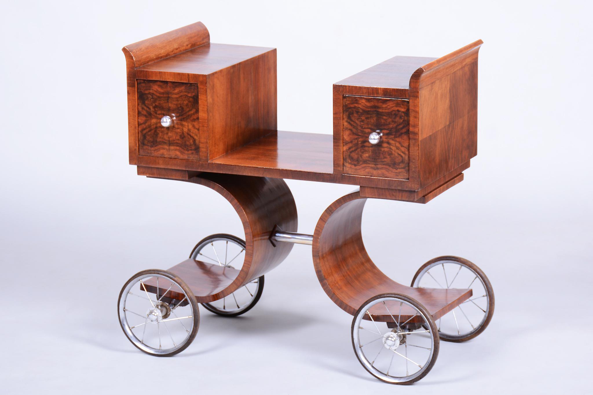 Este elegante carro de servir Art Déco procede de Francia y data de los años veinte. Es la personificación del lujo y el diseño práctico típicos de esta época.

El carrito está chapado con una rica chapa de nogal, que luce un distintivo y bello