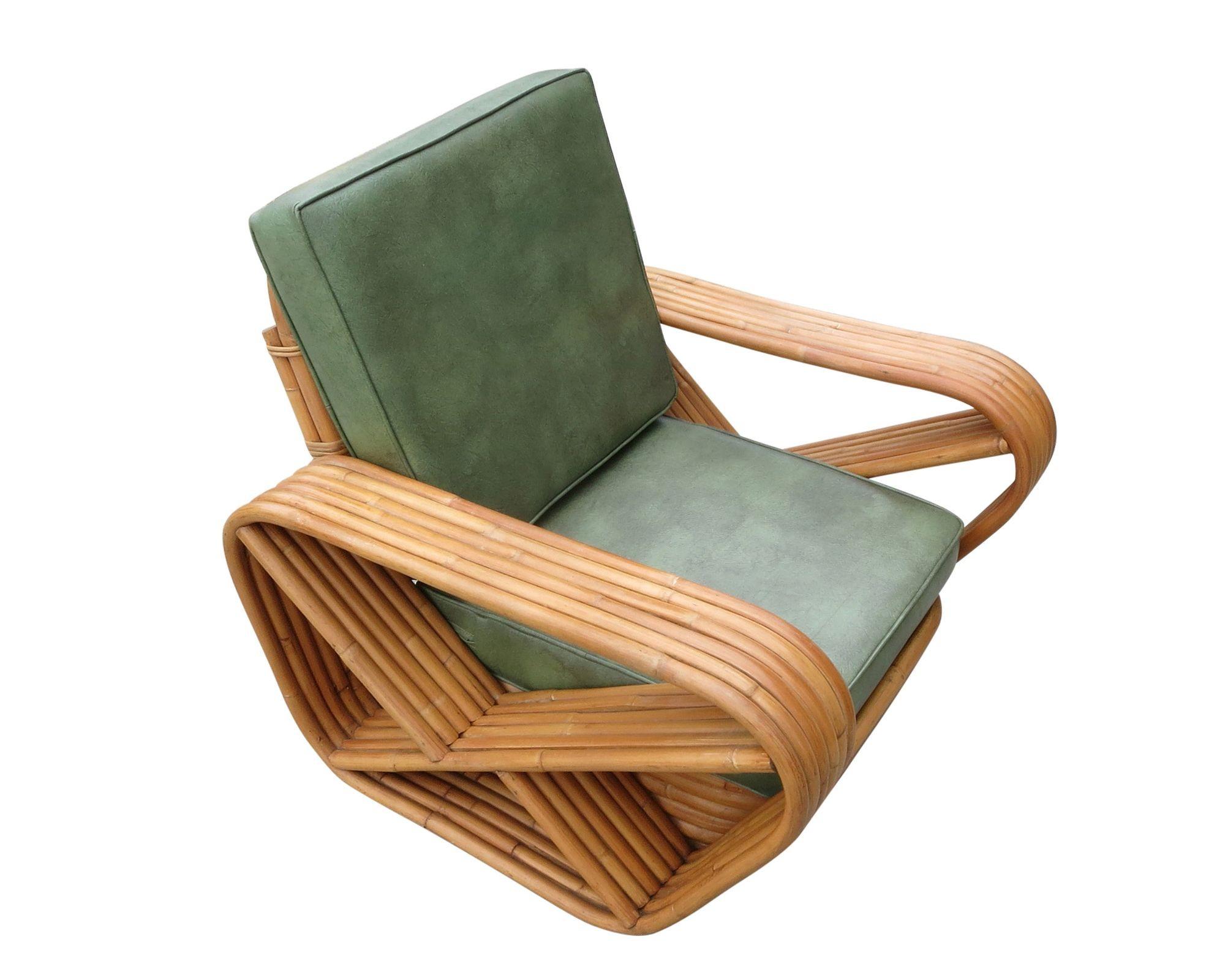 Art Deco-Sessel aus Rattan mit sechs Strängen, quadratischen Brezelarmen und einem klassischen, gestapelten Untergestell. Im Lieferumfang ist der passende gestapelte Rattan-Ottoman enthalten.

Maßgefertigte Kissen C.O.M. (Costumers Own Material)