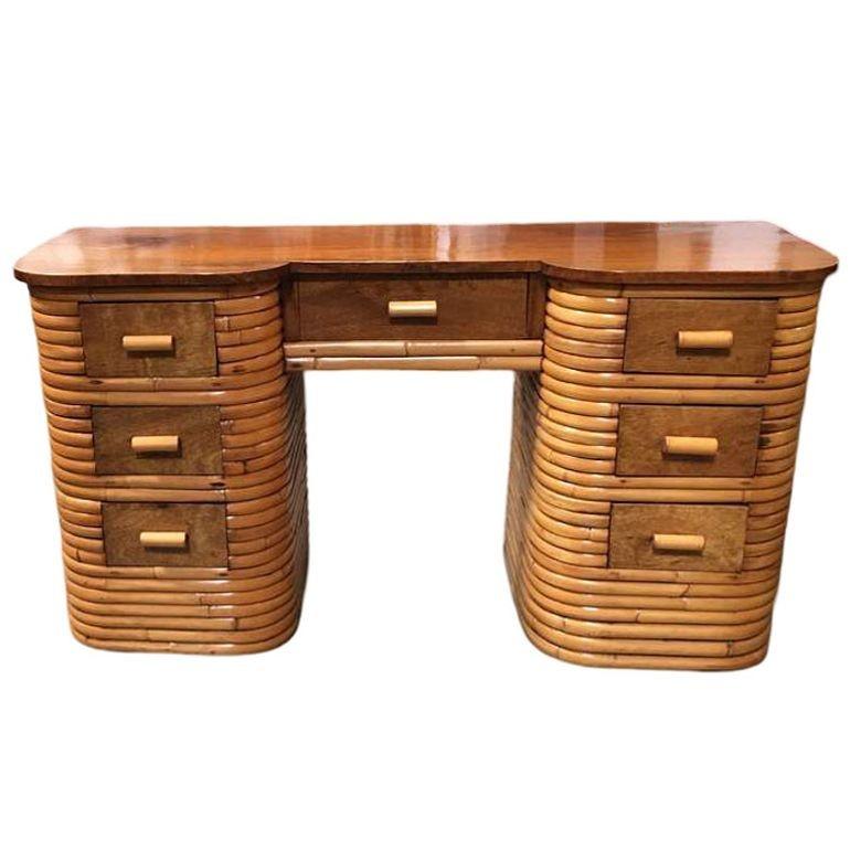 This beautifully restored Paul Frankl-inspired stacked rattan secretary desk with a mahogany top, center drawer with two sets of drawers on each side of the desk all encased in stacked Rattan Base. The desk features a center drawer and 6 side