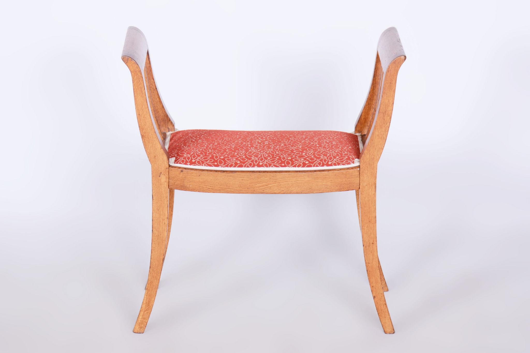 Dieser elegante Art-Déco-Hocker wurde in der Tschechoslowakei aus massiver Eiche hergestellt. Die ursprüngliche Lackierung wurde wiederhergestellt, was dem Stück ein authentisches Aussehen verleiht und die Schönheit des Holzes hervorhebt.

Die neue