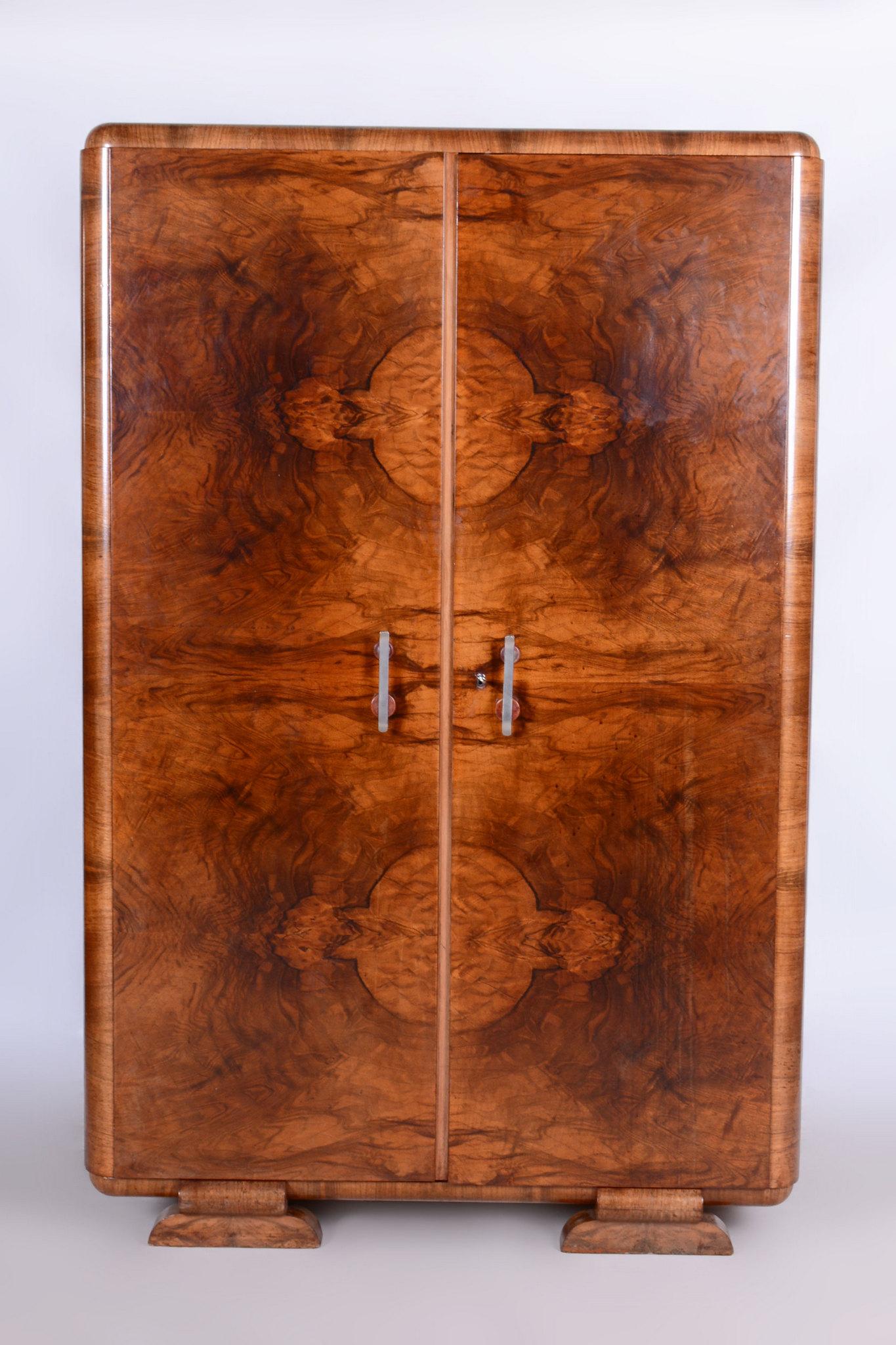 This Art Deco wardrobe originates from Czechoslovakia and dates back to the early 20th century. It was designed by the renowned architect Jindřich Halabala and manufactured by UP Závody Brno.

The wardrobe is made of Caucasian walnut. It has been