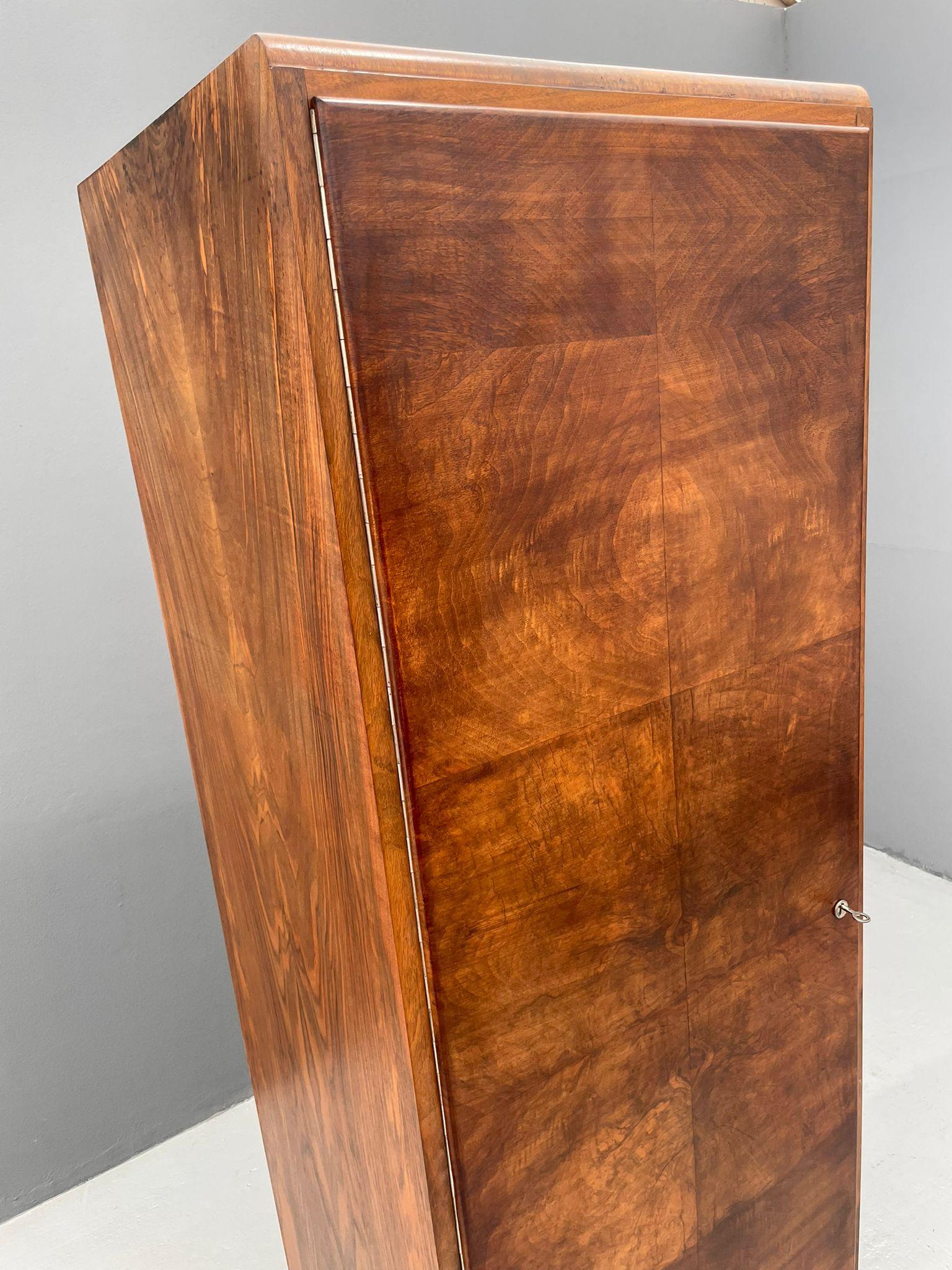 Questo armadio Art Deco restaurato è stato realizzato in Cecoslovacchia intorno agli anni Trenta. Il pezzo è stato completamente restaurato, rivelando la splendida impiallacciatura di noce con le sue ricche venature e la sua forma
