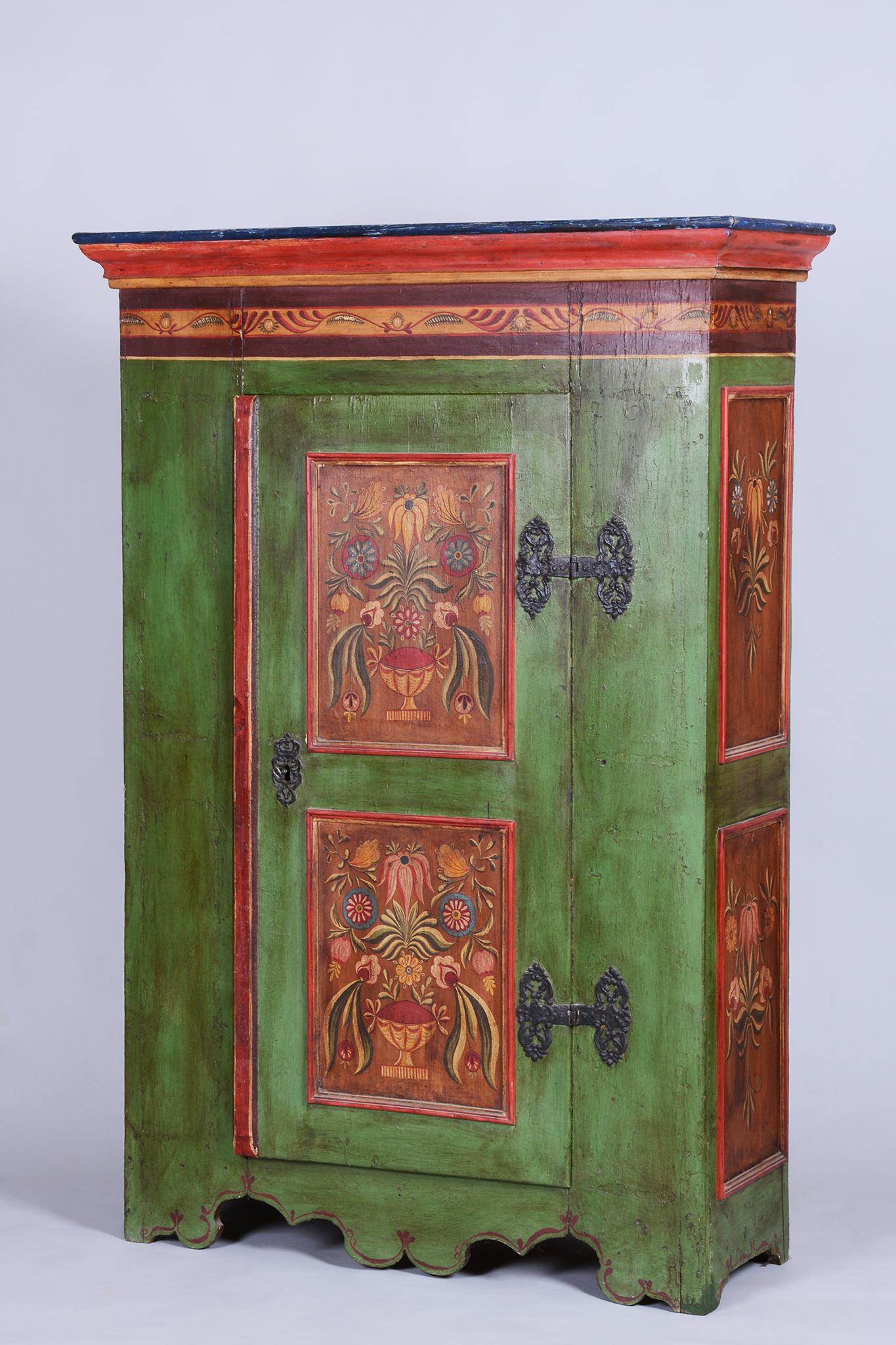 This charming painted cabinet in the Baroque style originates from Bohemia from the early 19th century. It is crafted from solid spruce wood and adorned with original paintings featuring floral patterns, which lend it a unique and authentic