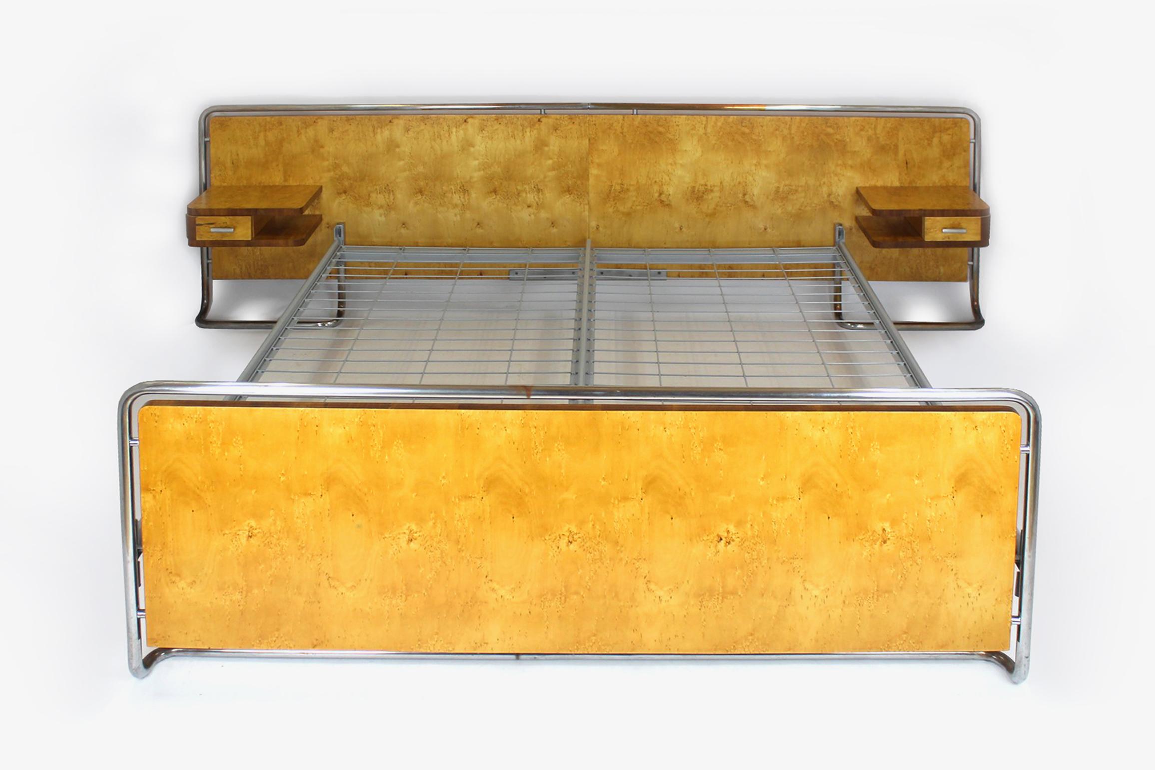 
Dieses Bett im Bauhaus-Stil wurde von Rudolf Vichr in den 1940er Jahren in der Tschechoslowakei hergestellt.
Das Set besteht aus einem Doppelbett und zwei aufgehängten Nachttischen. Die Möbel sind mit zwei Holzarten furniert, das Gestell besteht