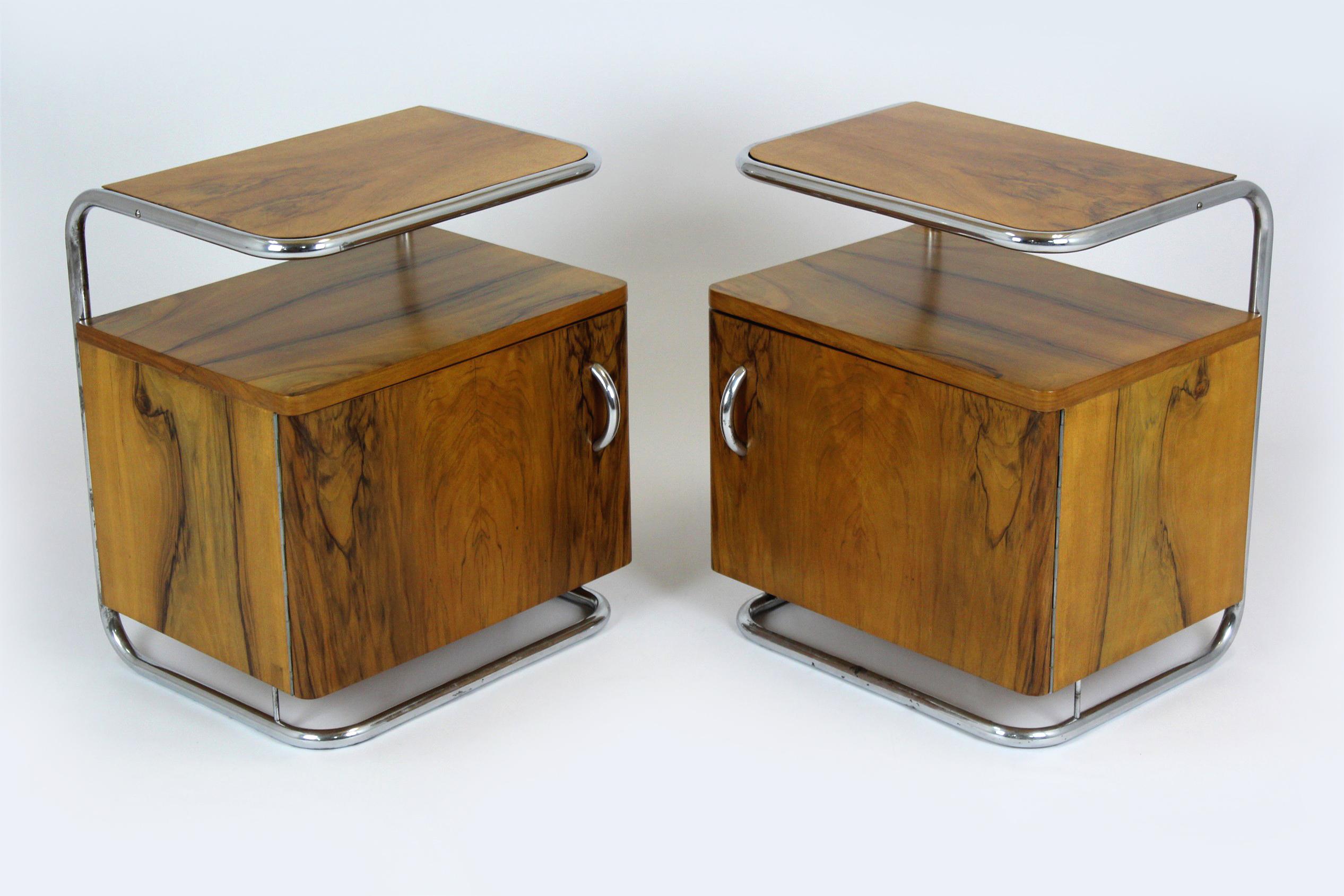 A pair of bauhaus style nightstands, made in the 1930s in Czechoslovakia. The frame is made of chrome tubular steel, the cabinets are walnut. The tables have been restored, the wood is varnished in a satin finish. Chrome elements are preserved in