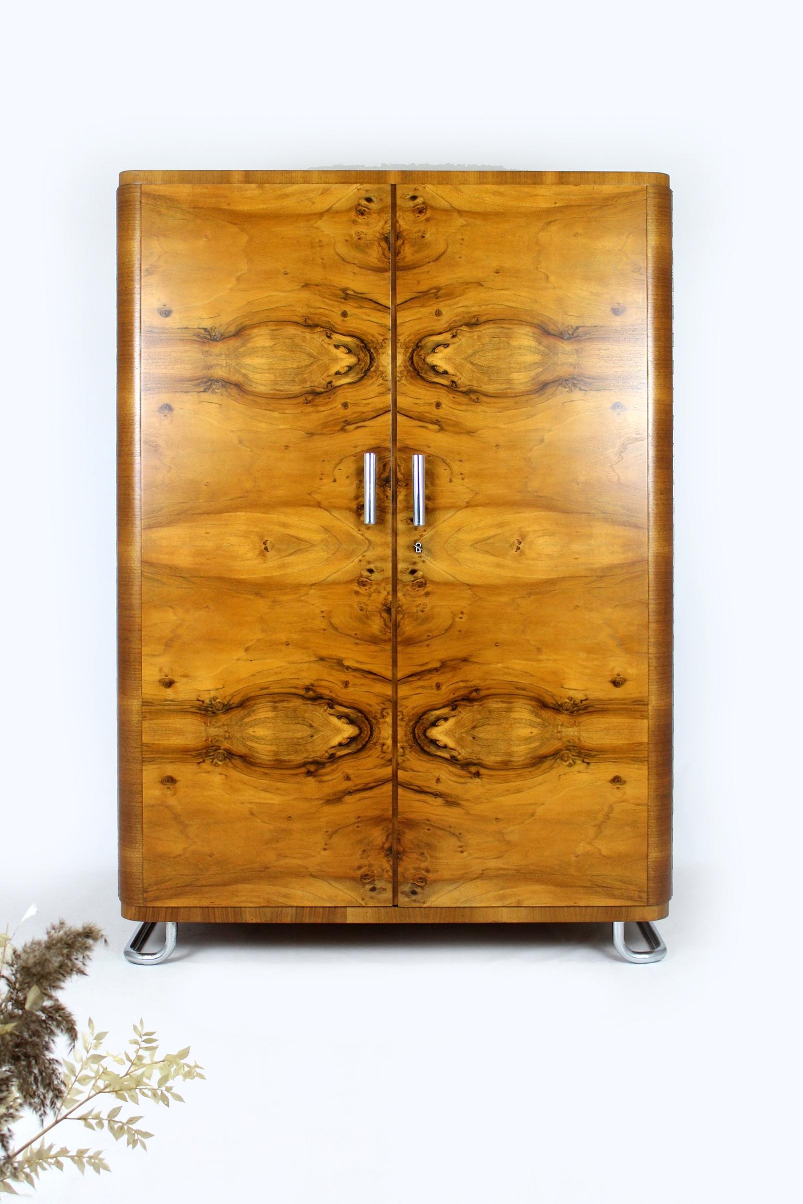 Dieser Kleiderschrank im Bauhaus-Stil aus Nussbaumholz wurde in den 1930er Jahren von Hynek Gottwald in der Tschechischen Republik hergestellt. Mit Kleiderstange und vier Einlegeböden. Der Schrank steht auf verchromten Stahlrohrfüßen und hat