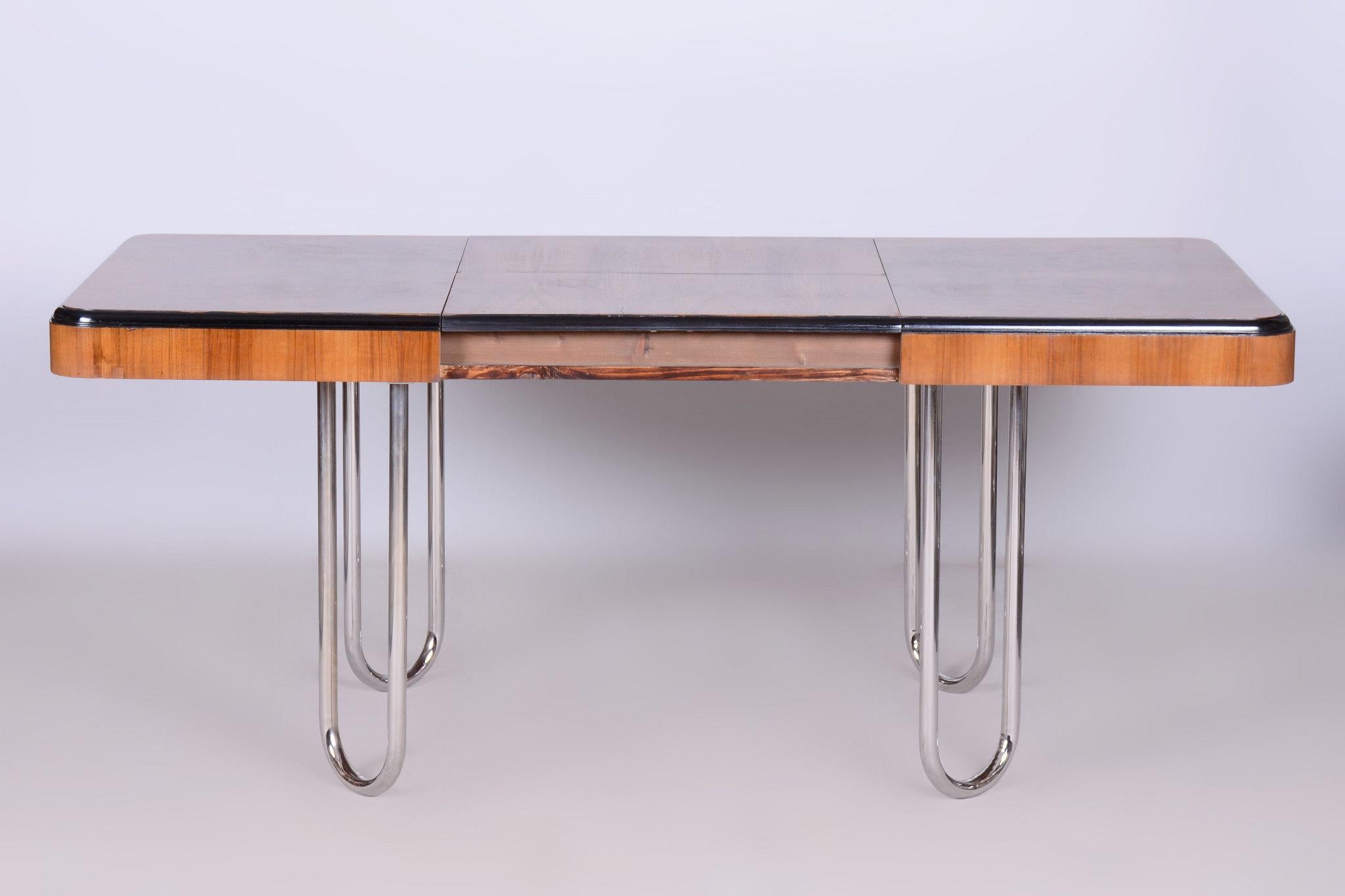 This extendable dining table in Bauhaus style originates from Czechoslovakia in the first half of the 20th century. The legs are made of tubular chrome steel, and the tabletop is made of wood with a walnut veneer.

The table has been professionally
