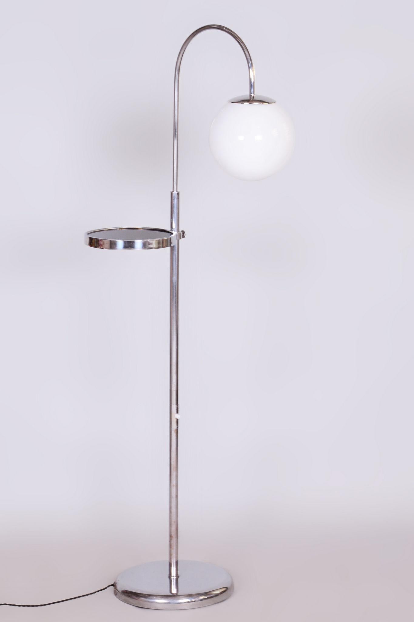 Restored Bauhaus floor lamp

Origin: Czechia 
Period: 1930-1939
Material: Chrome-plated steel, milk glass

Adjustable lamp height (167 - 185 cm).

Adjustable shelf height.

The chrome parts have been cleaned and professionally restored. 			

This