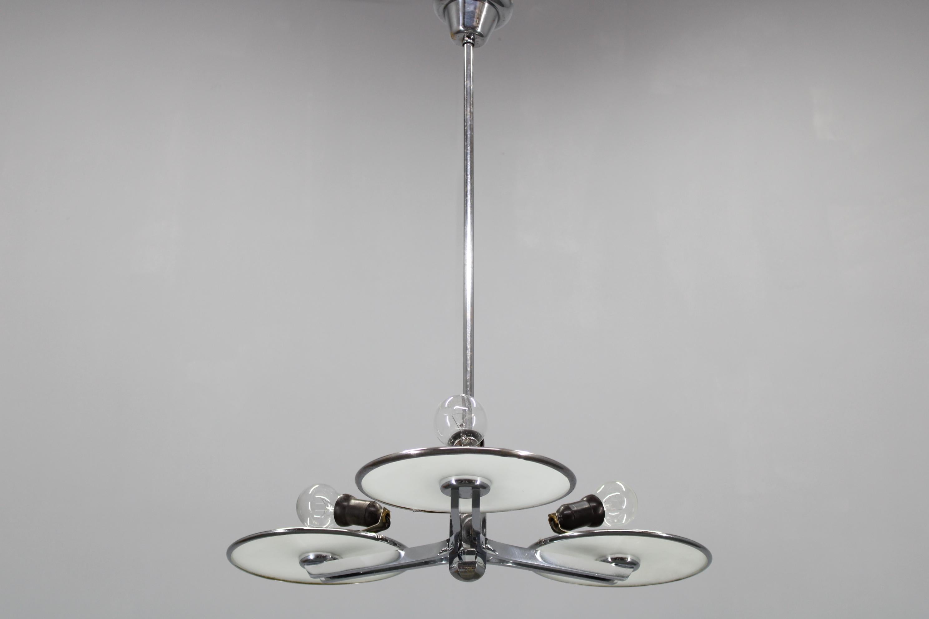 Ein exquisiter Kronleuchter aus der Tschechoslowakei aus den 1940er Jahren mit Merkmalen des Bauhaus- und Art-déco-Designs. 
   Die Struktur aus verchromtem Eisenblech und die milchigen Glasschirme verleihen der Leuchte ein raffiniertes
