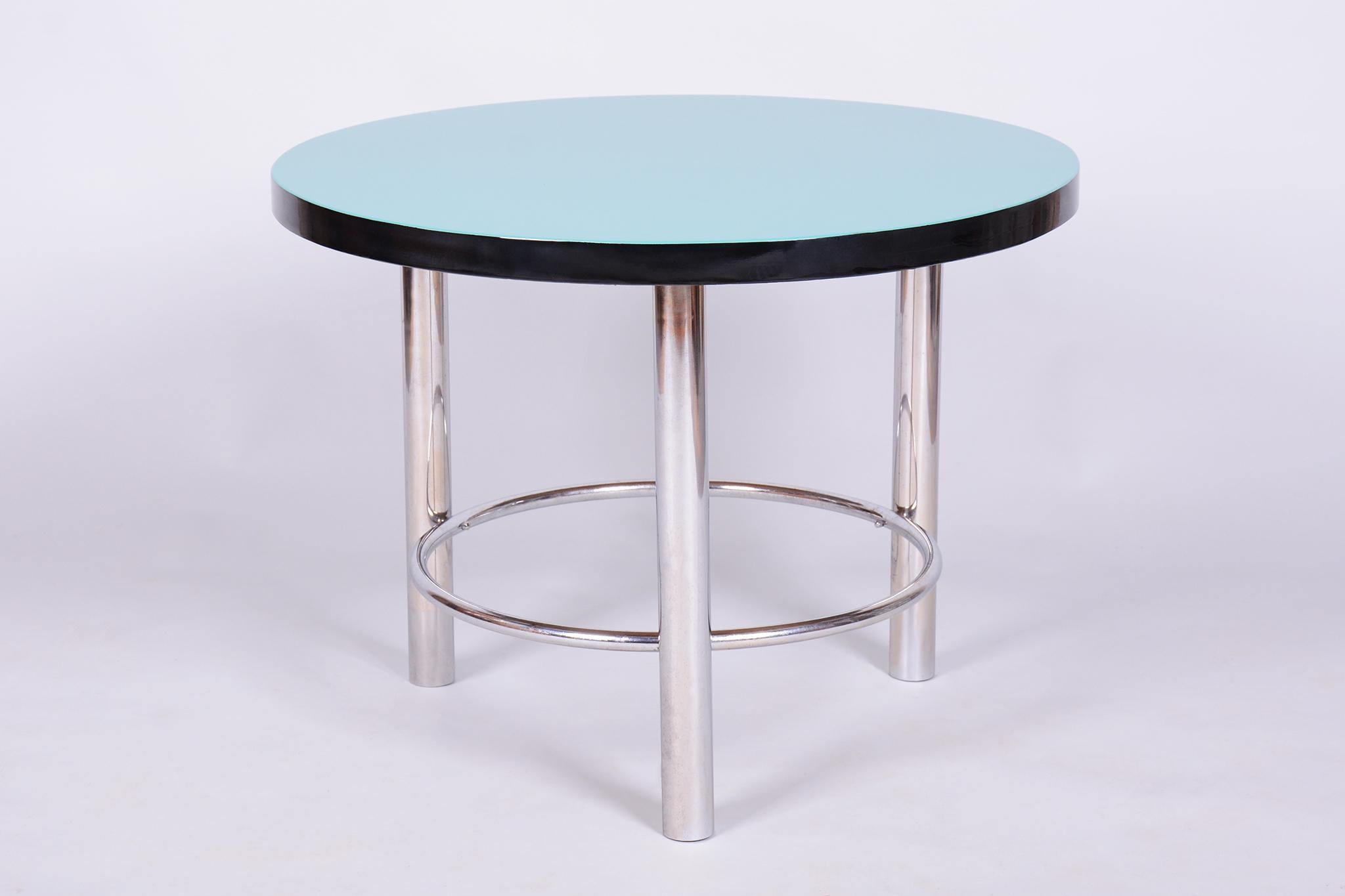 Cette élégante table ronde de style Bauhaus est originaire de Tchécoslovaquie et date de la première moitié du XXe siècle. Il incarne le design minimaliste et fonctionnel typique du mouvement Bauhaus.

La table est fabriquée en acier tubulaire