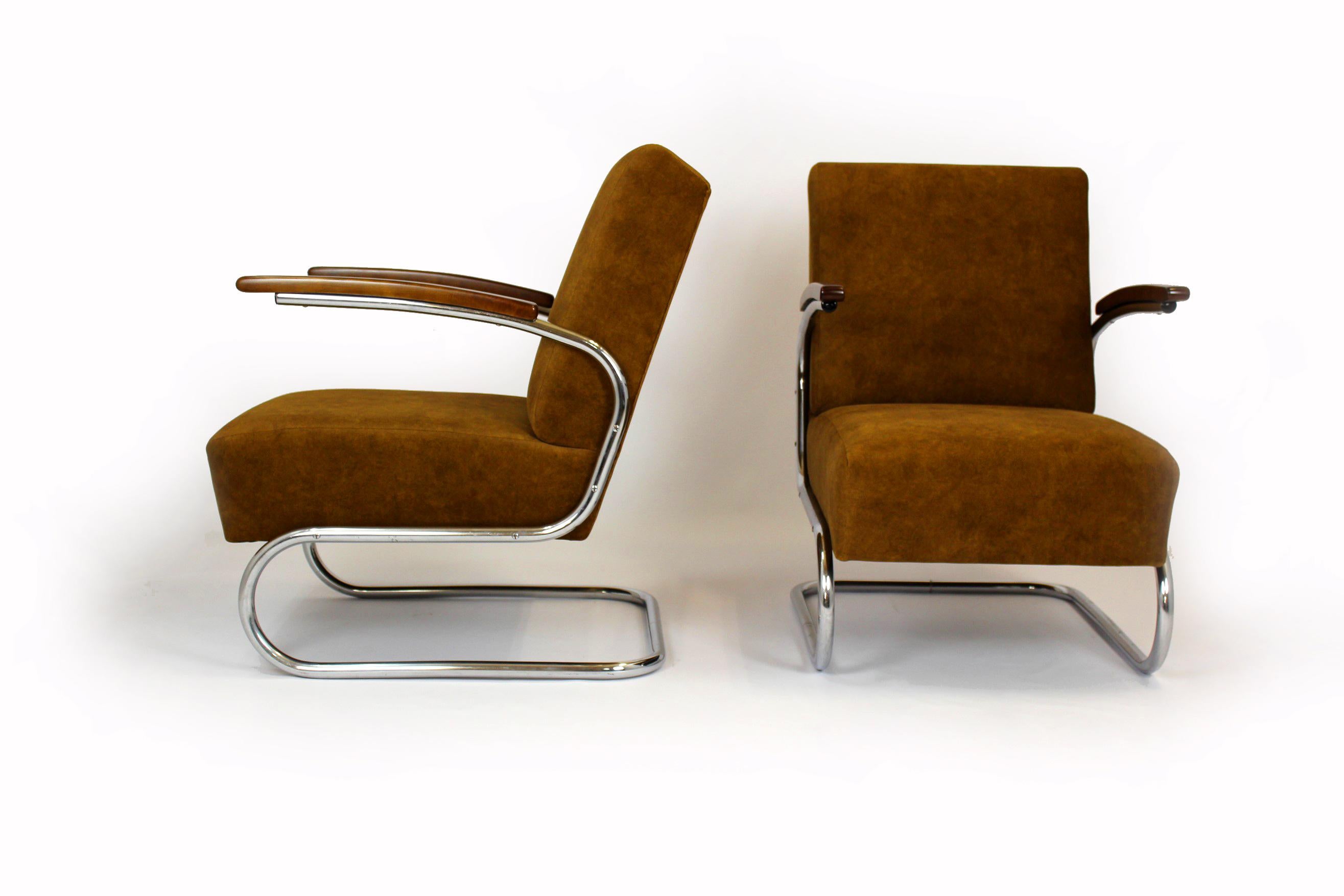 Set of two Bauhaus style cantilever S411 armchairs with a lacquered wood and chrome tubular steel frames. Designed in the 1930s by Willem Hendrik Gispen and manufactured by Mücke Melder under Thonet license.
The armchairs have been completely