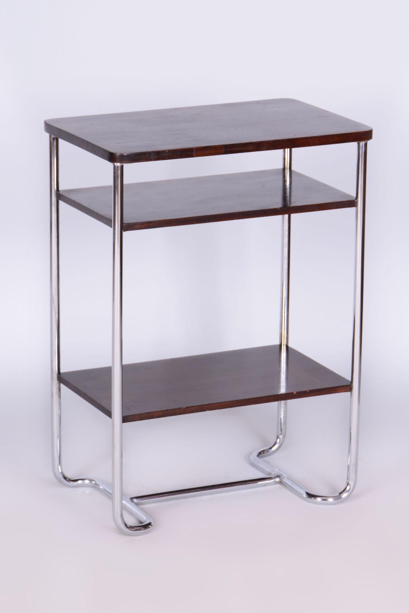 Questo elegante tavolino Bauhaus proviene dalla Cecoslovacchia e risale alla prima metà del XX secolo. È realizzata in tubolare d'acciaio cromato e listellare d'abete impiallacciato in noce scuro. Il tavolo colpisce per il suo design senza tempo e
