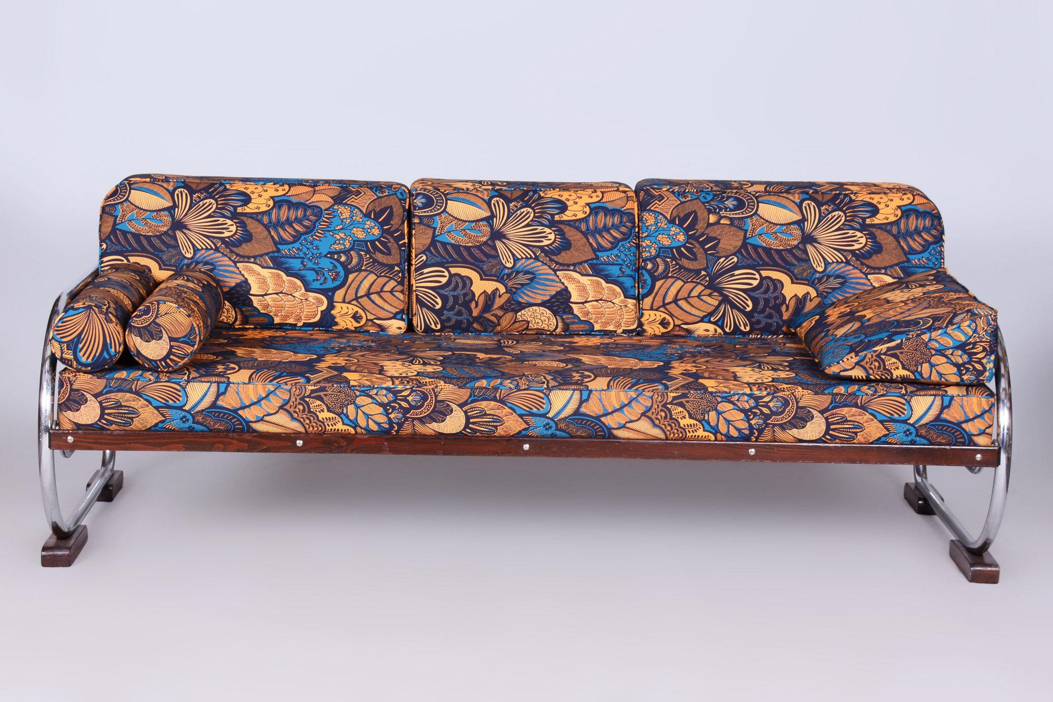 This Bauhaus-style sofa originates from the first half of the 20th century and was manufactured by Robert Slezák. The frame is made of tubular chrome-plated steel, which has been expertly cleaned.

The original polish on the beech armrests has been