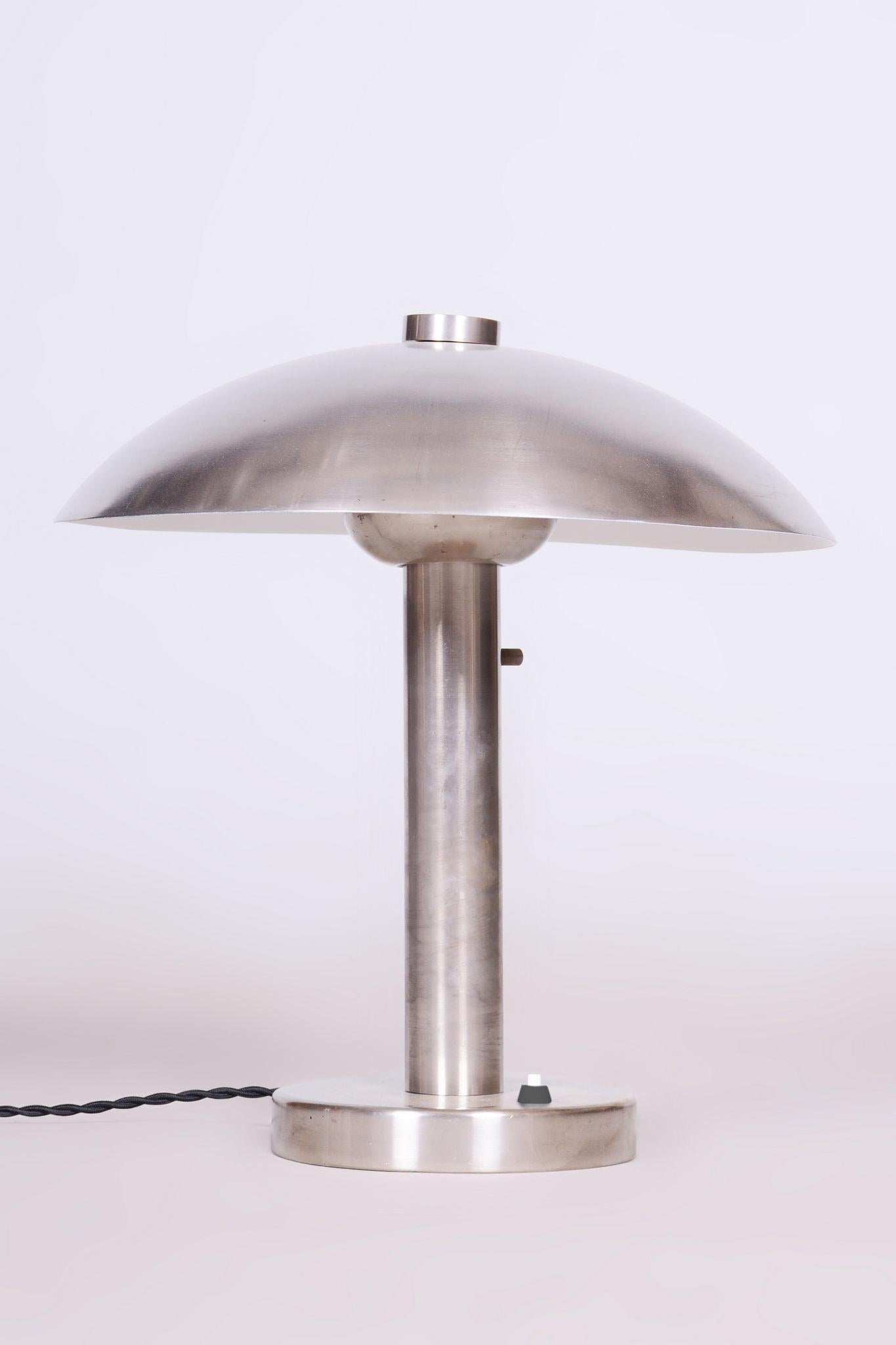 Restored table lamp 

Origin: Czech
Period: 1920-1929
Material: Nickel-plated steel

Uniquely designed adjustable light intensity by moving the bulb.

This item has new fully functioning electrification. 

Our professional refurbishing team in