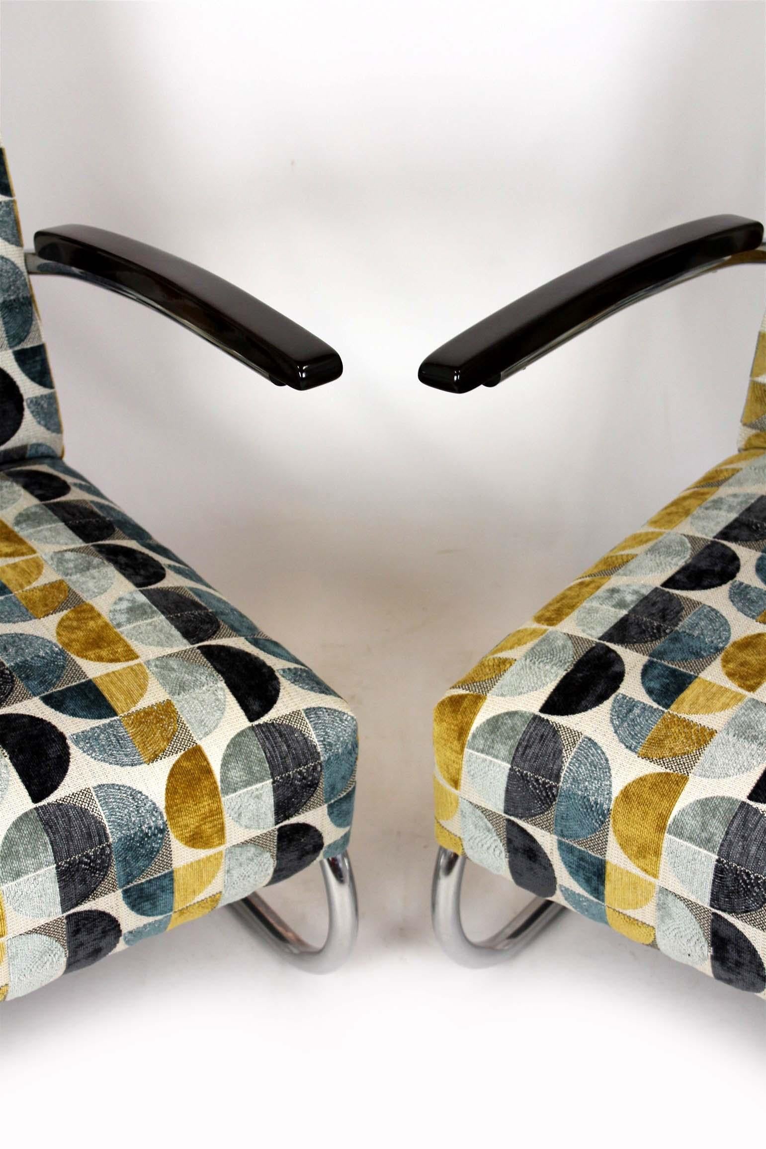 Set of two Bauhaus style cantilever S411 armchairs designed in the 1930s by Willem Hendrik Gispen and manufactured by Mücke Melder.

These iconic armchairs feature lacquered wooden armrests and chrome-plated tubular steel frames. The pieces have