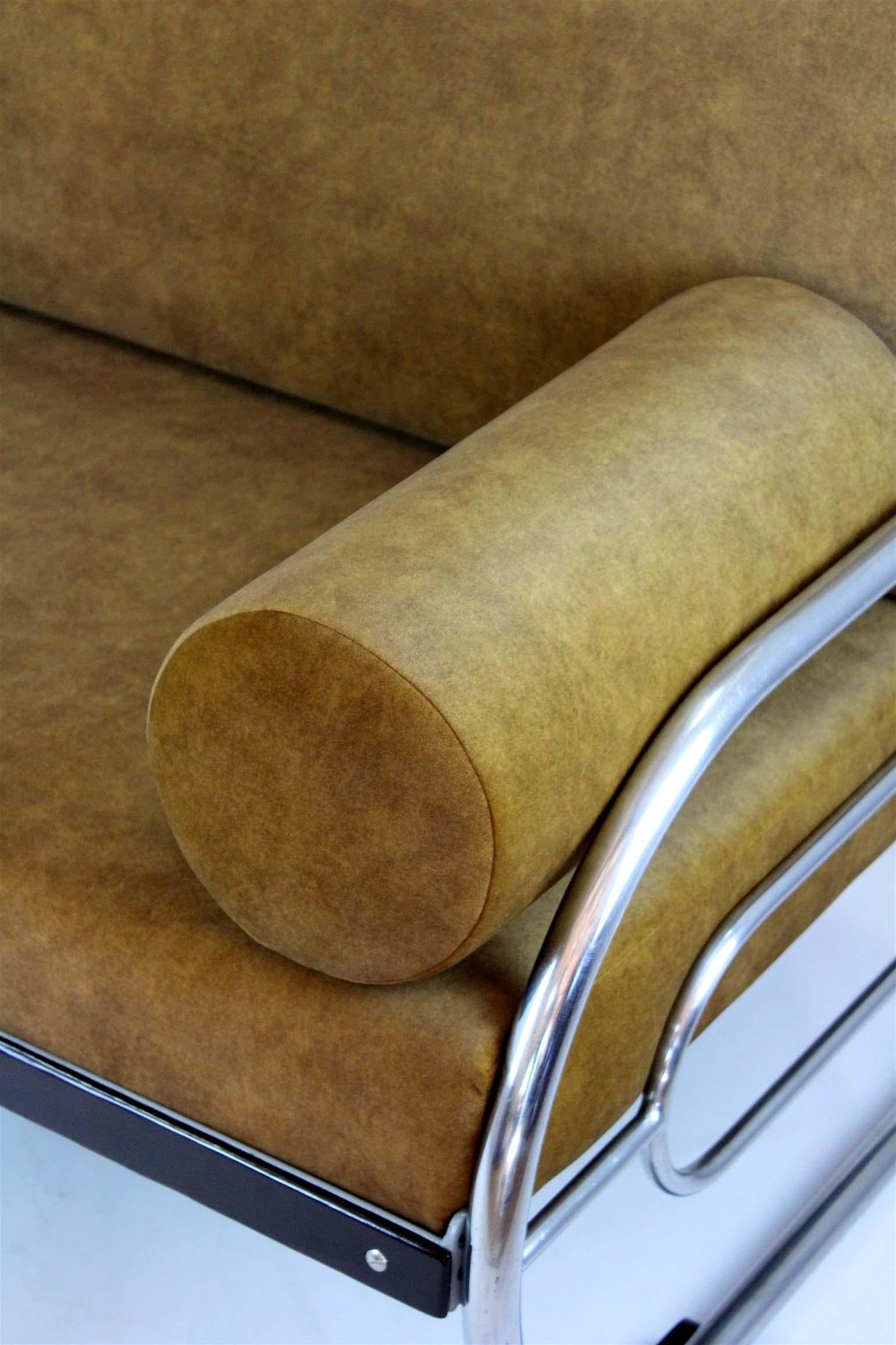 This Bauhaus-style sofa was produced by Hynek Gottwald in the 1930s. It has been fully restored with new mattresses upholstered in an easy-to-clean fabric. The wooden elements have been lacquered, and the chrome parts remain in their original