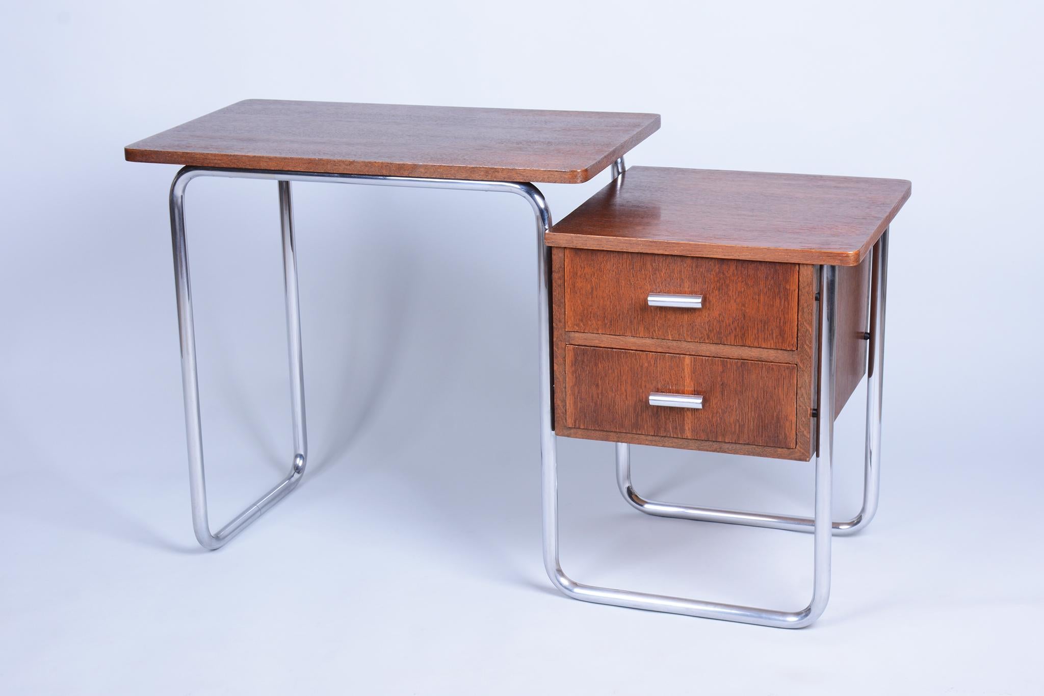 This elegant Bauhaus writing desk originates from Czechoslovakia from the 1930s. It is an authentic piece from the renowned manufacturer Robert Slezák, as evidenced by its preserved original label.

The desk features a minimalist tubular