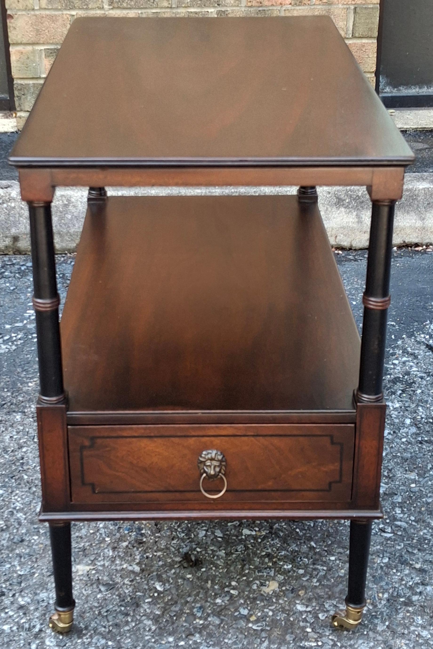 A Fully Restored Beacon Hill Collection Inlaid Mahogany Tiered  Rolling Side Table with double sided single drawer. Ebonized Faux Bamboo Mahogany Legs, English Regency Style. Fully Refinished on all sides for versatile positioning in any room.