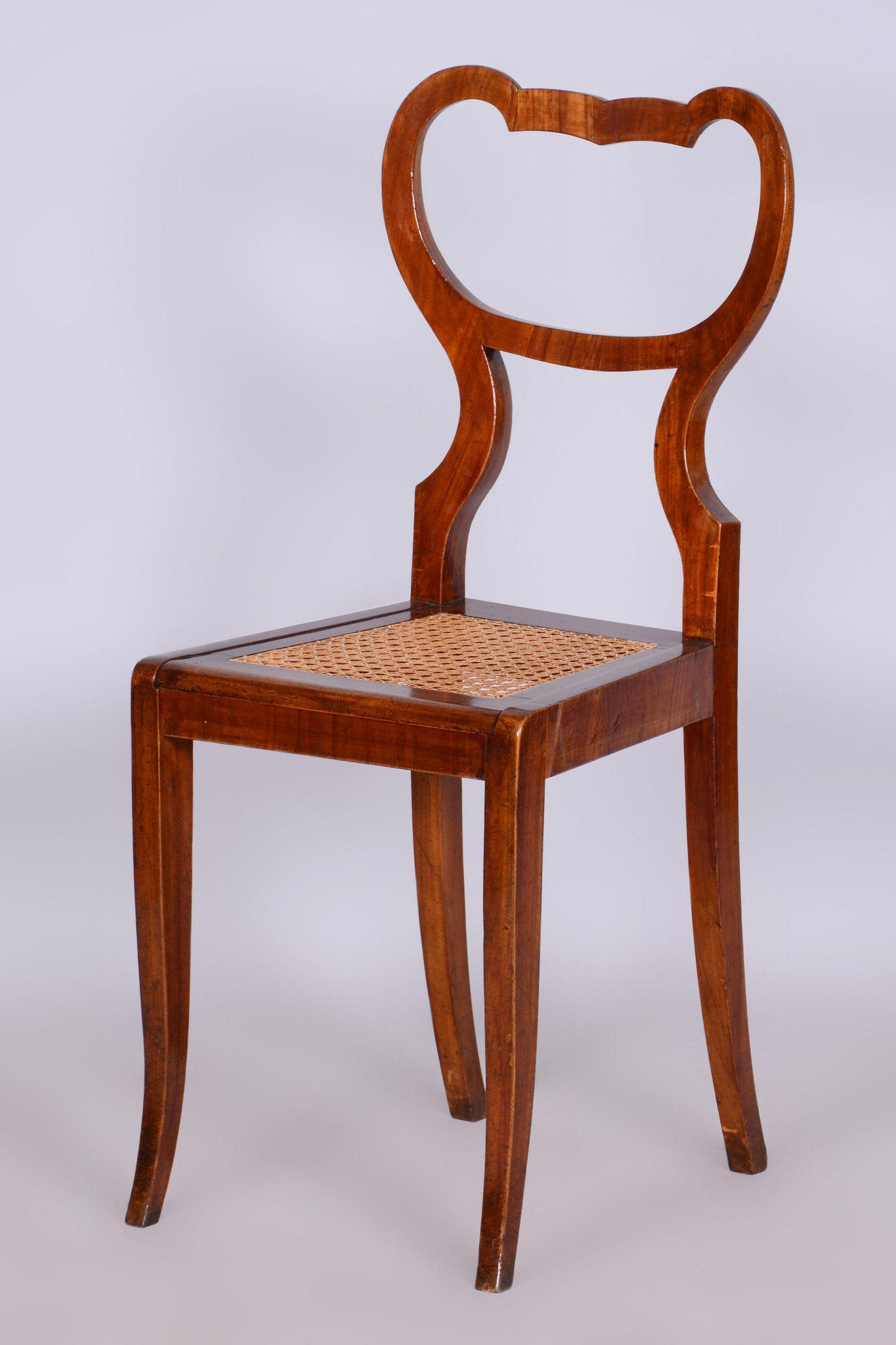 Dieser Biedermeier-Stuhl stammt aus Österreich und geht auf das frühe 19. Jahrhundert zurück. Er ist aus Nussbaumholz gefertigt und hat ein Rattangeflecht.

Der Stuhl wurde vollständig restauriert, und die Rattansitzfläche ist fest und unversehrt,