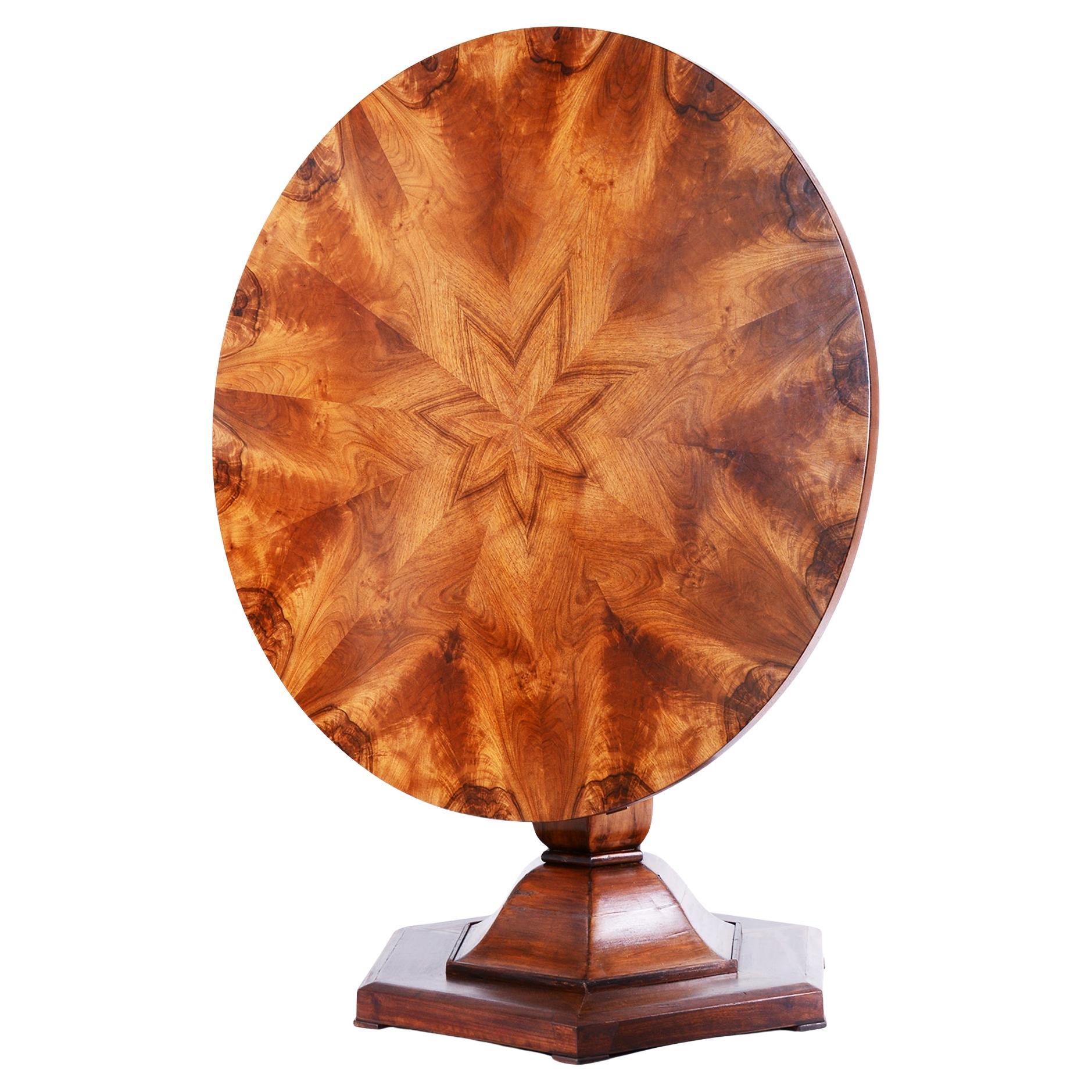 This elegant round Biedermeier dining table comes from Bohemia from the early 19th century. It is made of spruce blockboard veneered with walnut. The table has undergone careful restoration, during which its original shine and elegance were restored