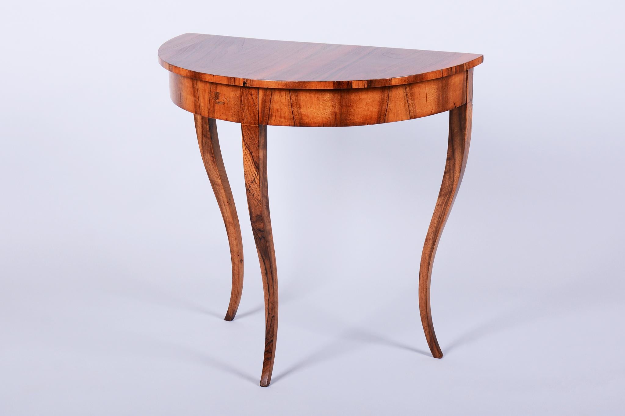 This elegant Biedermeier console table originates from Austria and dates to the early 19th century. It is a beautiful and very well-preserved original model, embodying the classic elegance of its era.

The construction is a robust combination of