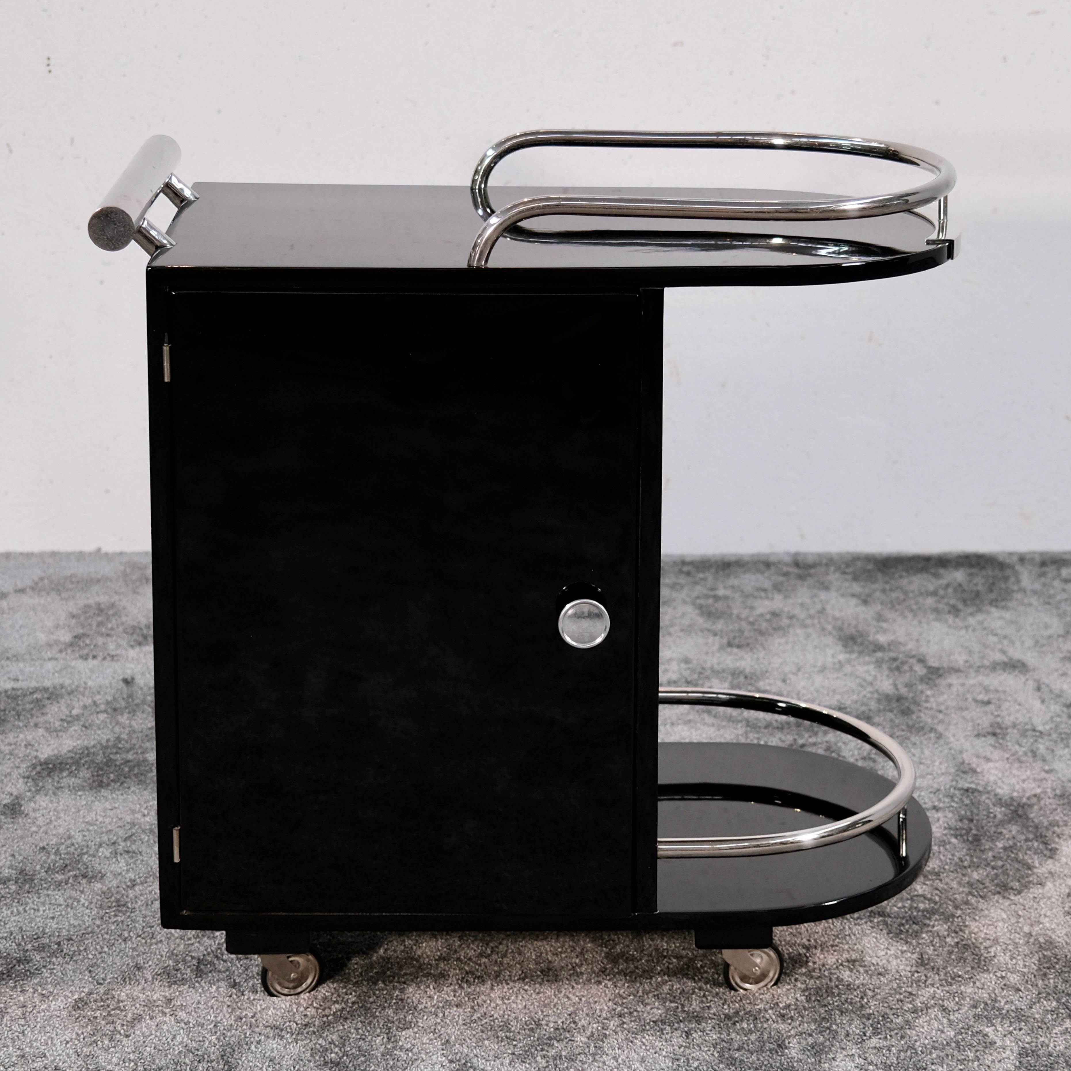 Questo raro e raffinato carrello da bar in stile Art Déco è un vero pezzo forte per gli amanti del design classico e dell'intrattenimento moderno. Che tu stia cercando un carrello da tè, un carrello per cocktail, un carrello per bevande o un mobile