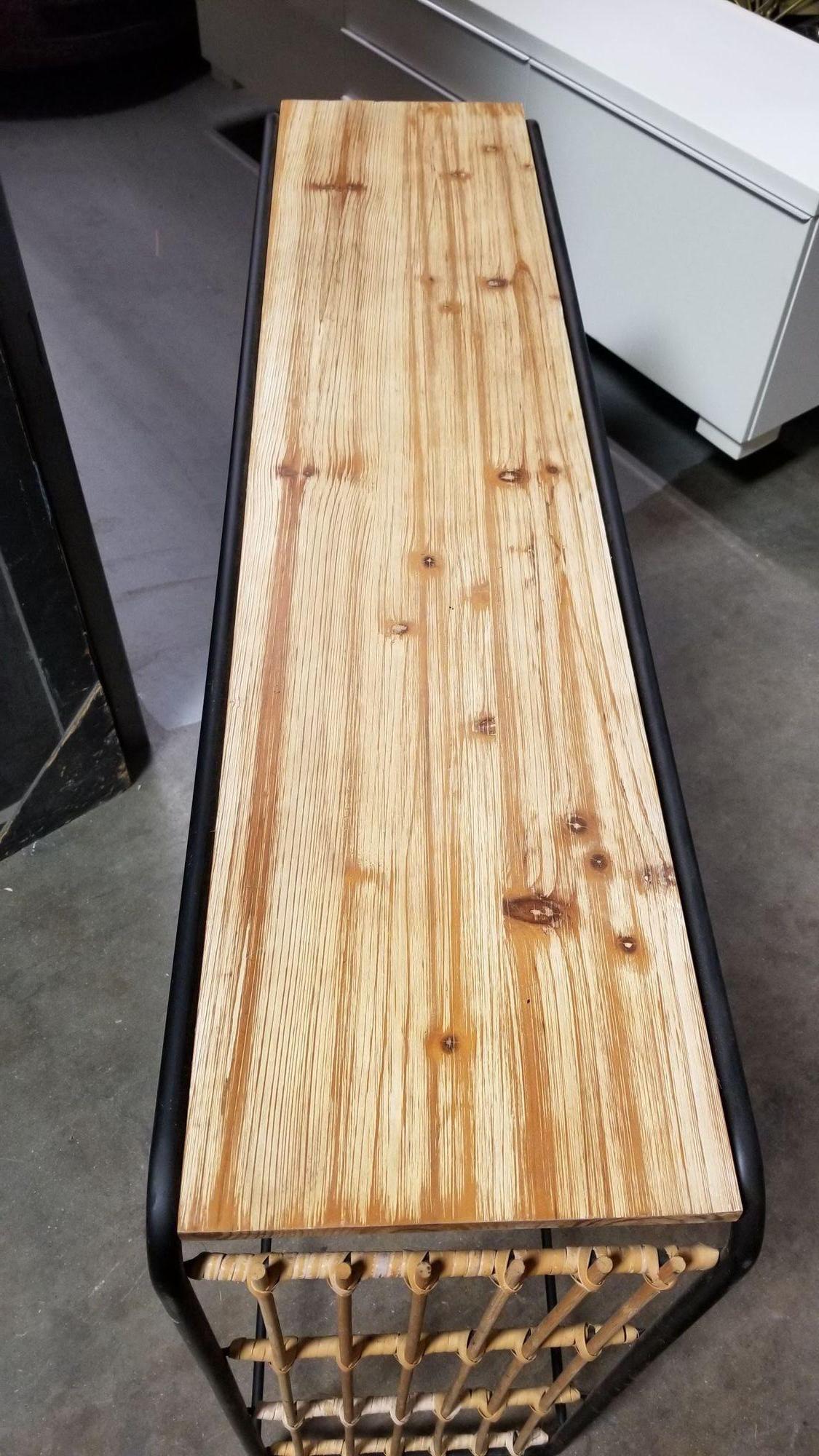 Eleva tu espacio con esta pequeña consola o mesa de entrada, con un elegante tablero de madera rubia, laterales de acero y tejido de ratán de caña. Su singular forma de cascada combina elementos modernos y naturales, convirtiéndola en un complemento