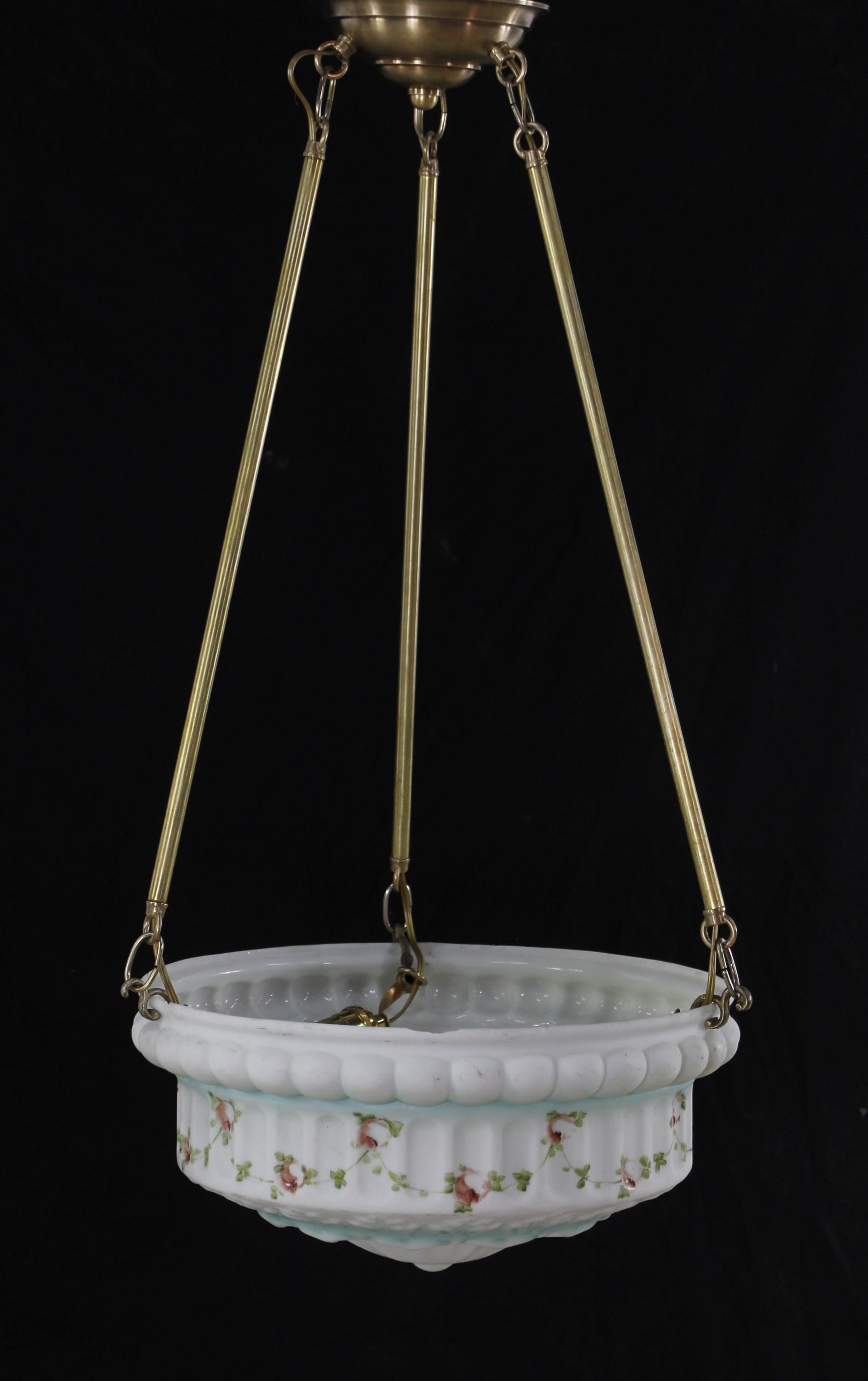 White cast glass antique dish pendant light with painted pink floral and green foliate details with splashes of blue. This light is suspended from three brass poles with a brass canopy. Cleaned and restored. There are minor chips along the rim and