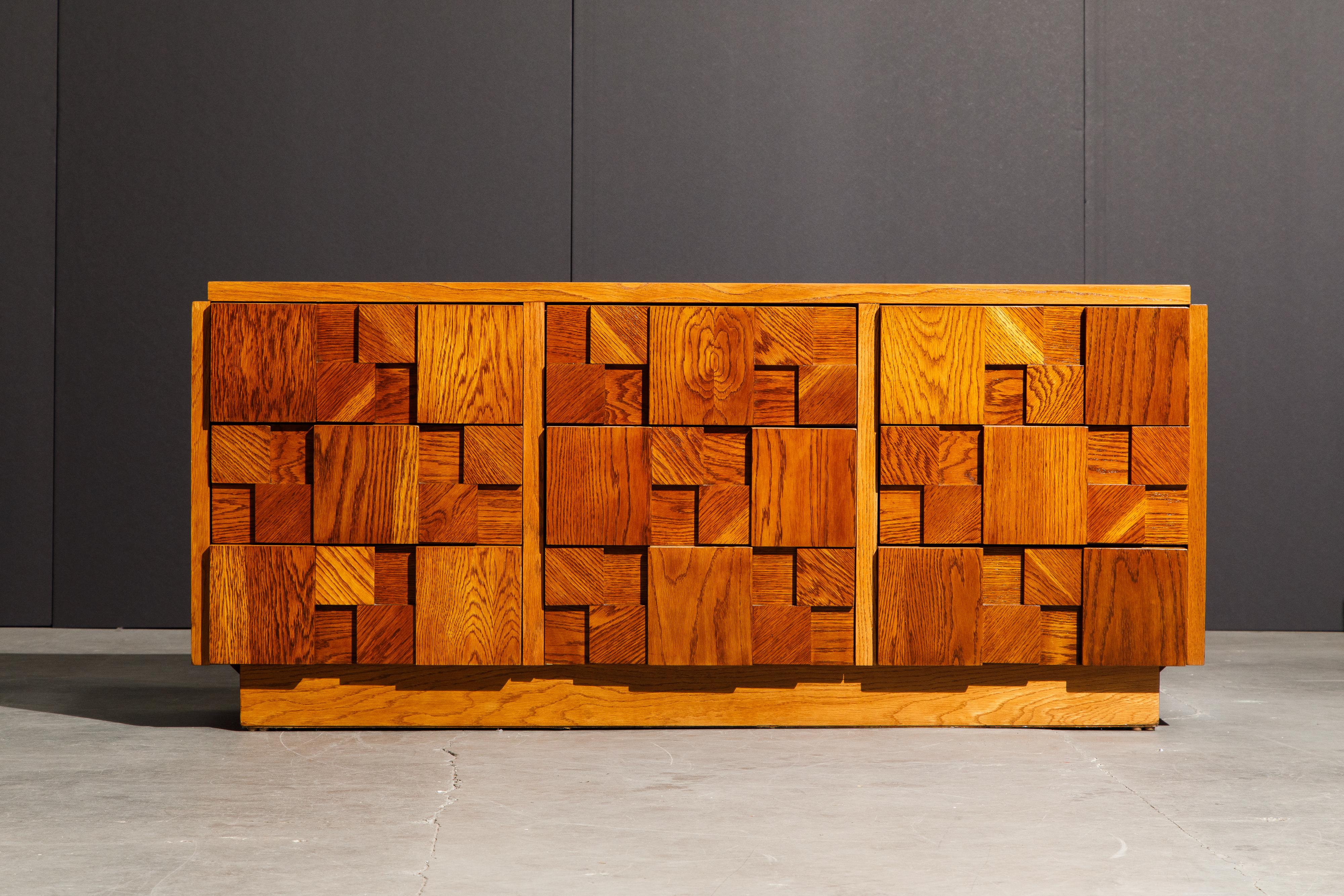 This fully restored Mid-Century Modern Brutalist dresser, created by Lane, features a cubist style wood arrangement across the front of the six dresser drawers. Each of the blocks of wood has a rich and unique grain, each going a different direction
