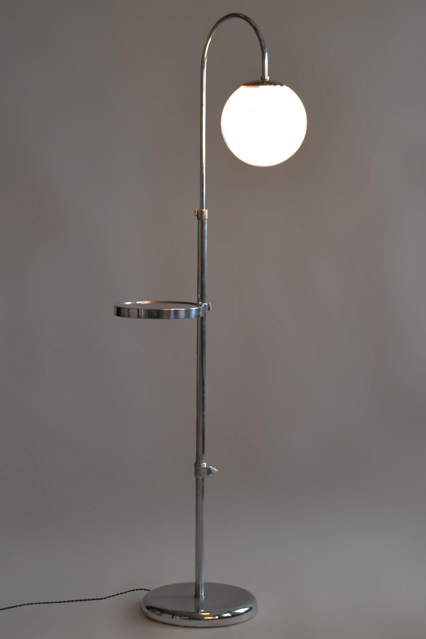 Restored Bauhaus floor lamp

Origin: Czechia 
Period: 1930-1939
Material: Chrome-plated steel, milk glass

Adjustable lamp height (167 - 185 cm).

Adjustable shelf height.

The chrome parts have been cleaned and professionally restored. 			

This